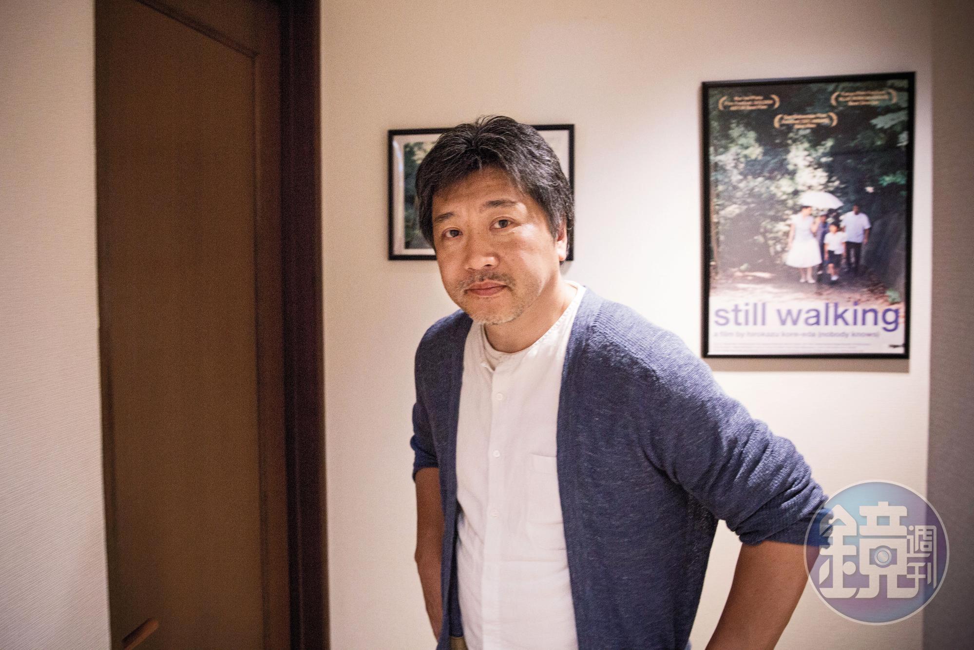 是枝裕和位在澀谷的工作室「分福」，走廊上掛滿了各階段的電影海報，經過的時候，像是穿越時光隧道。他身後的海報是《橫山家之味》。