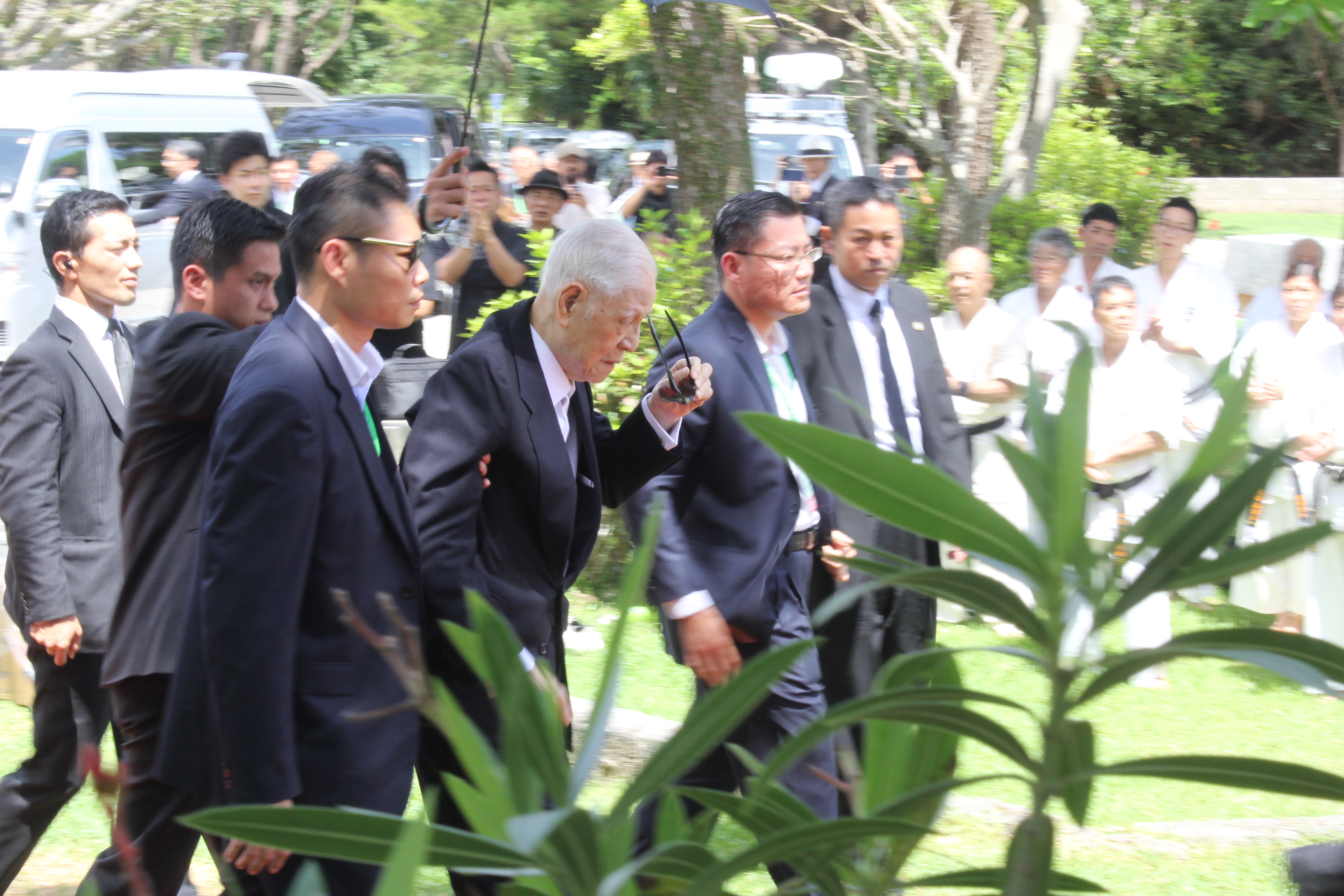 前總統李登輝抵達揭碑儀式會場時，由隨扈攙扶。