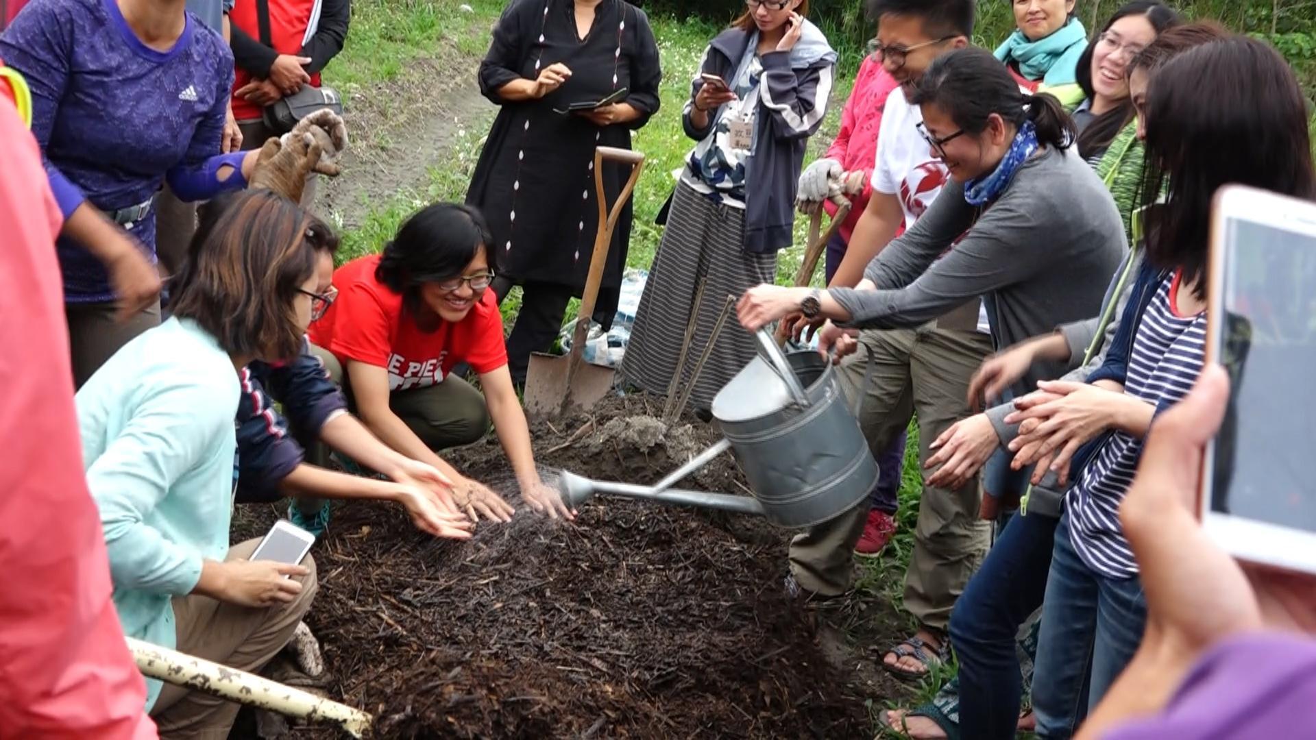 教育基地的堆肥，可以轉化成肥美的土壤。圖為學員學習搬動堆肥。