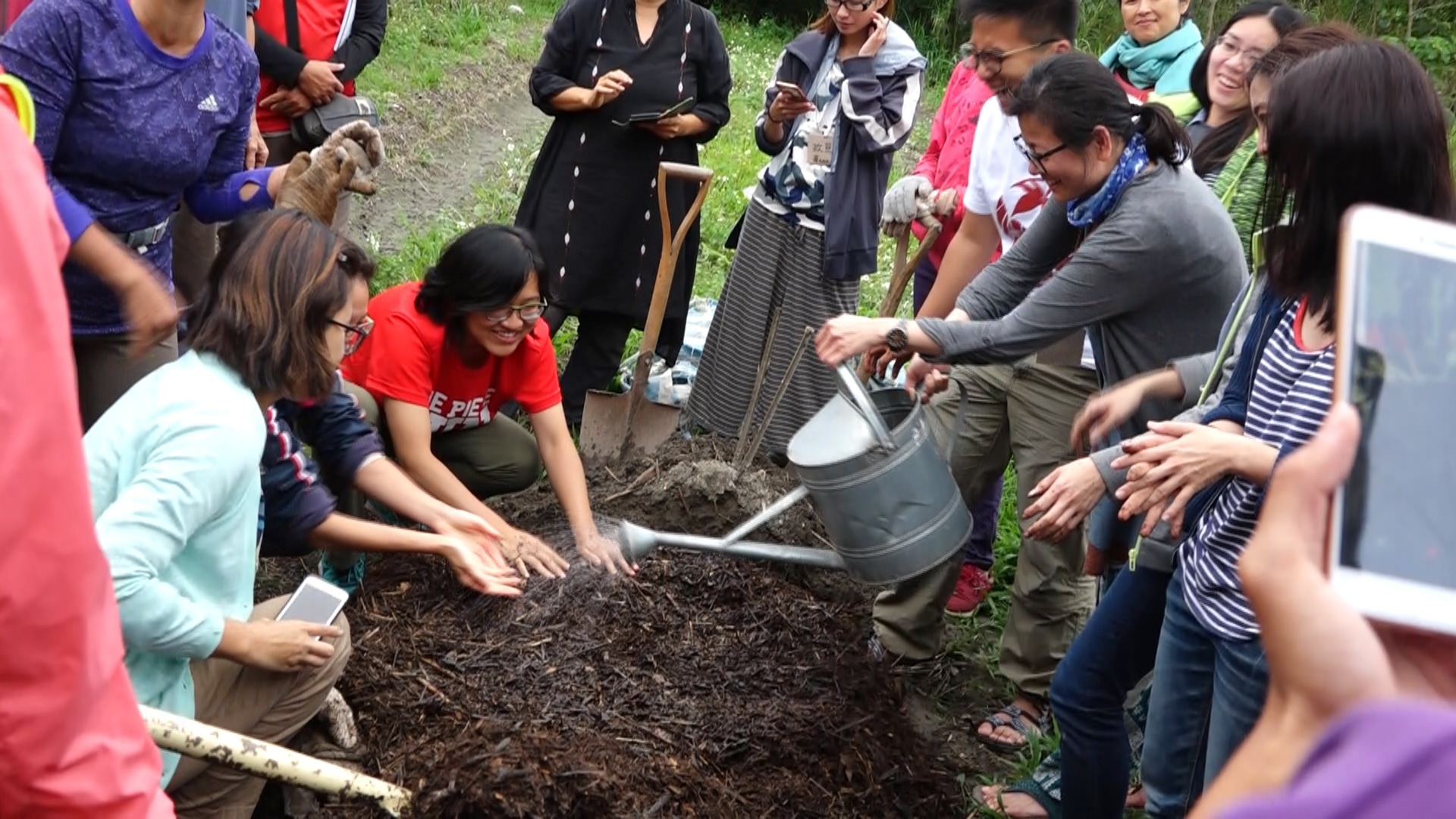 教育基地的堆肥，可以轉化成肥美的土壤。圖為學員學習搬動堆肥。