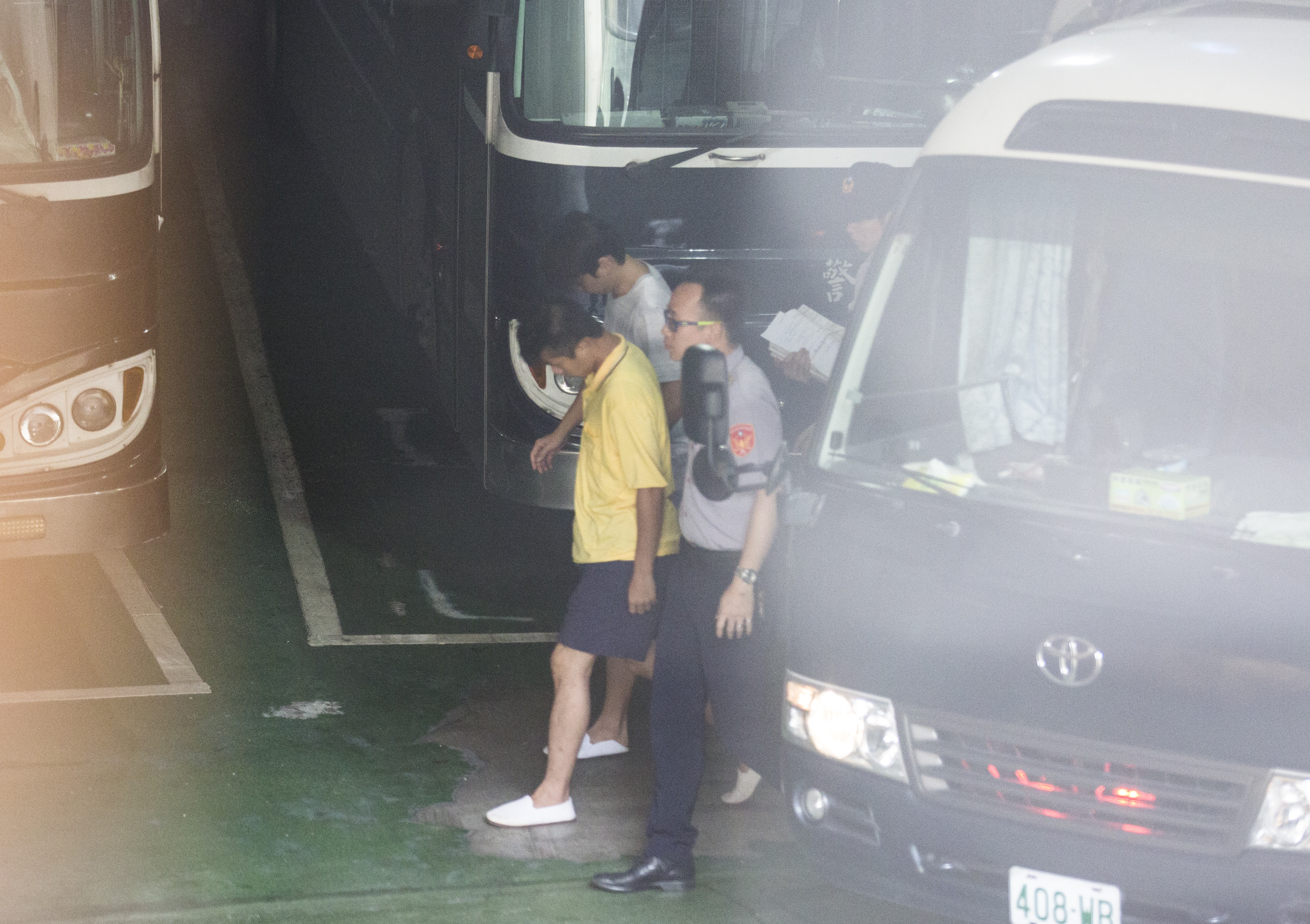 華山分屍案凶嫌陳伯謙（黃衣者）今上午遭提訊，在法警戒護下走下囚車，全程低頭不語。