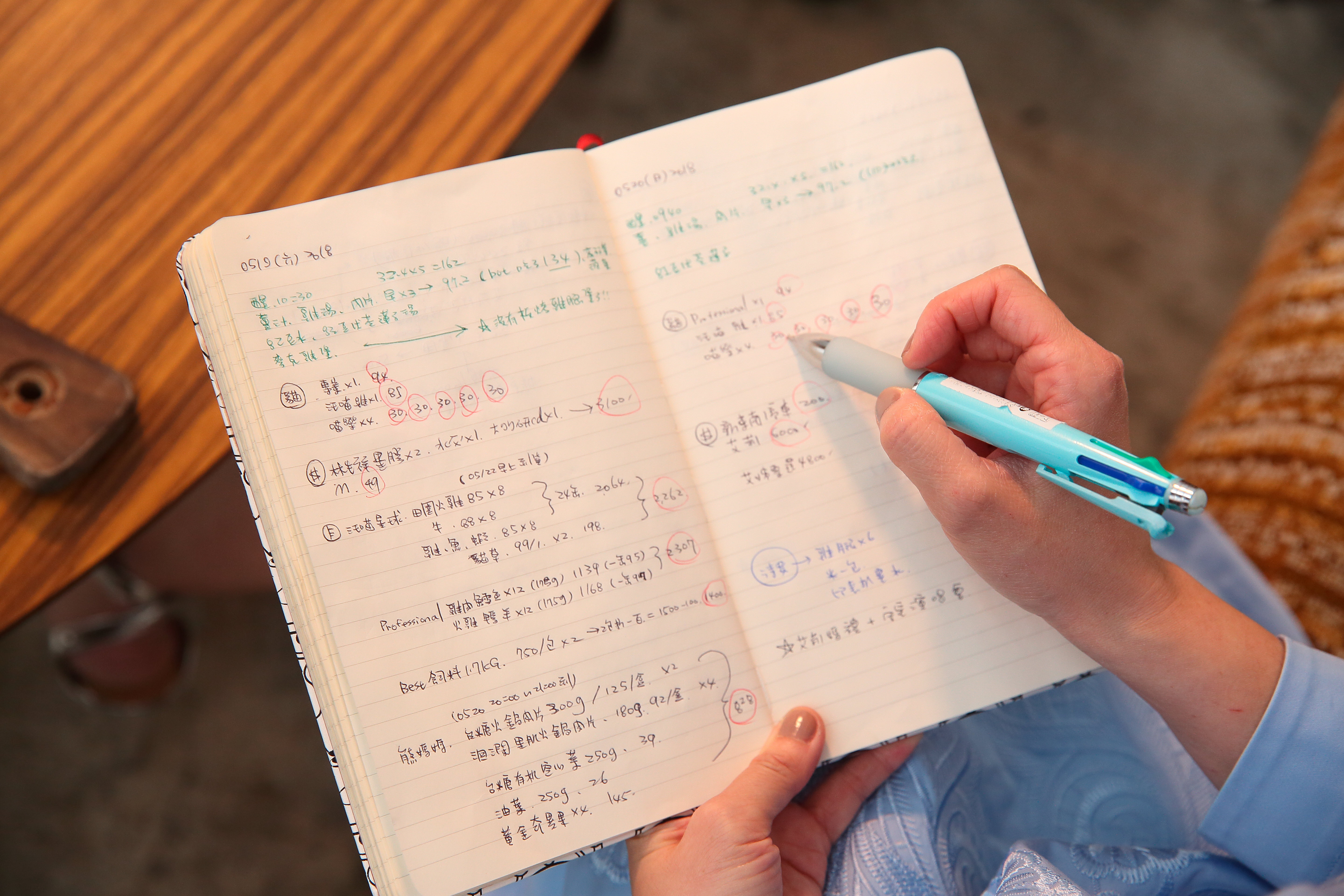 蔡燦得的筆記本記滿了採購的商品明細，吃完、用完她會用紅筆圈起來，等月底總結金額。