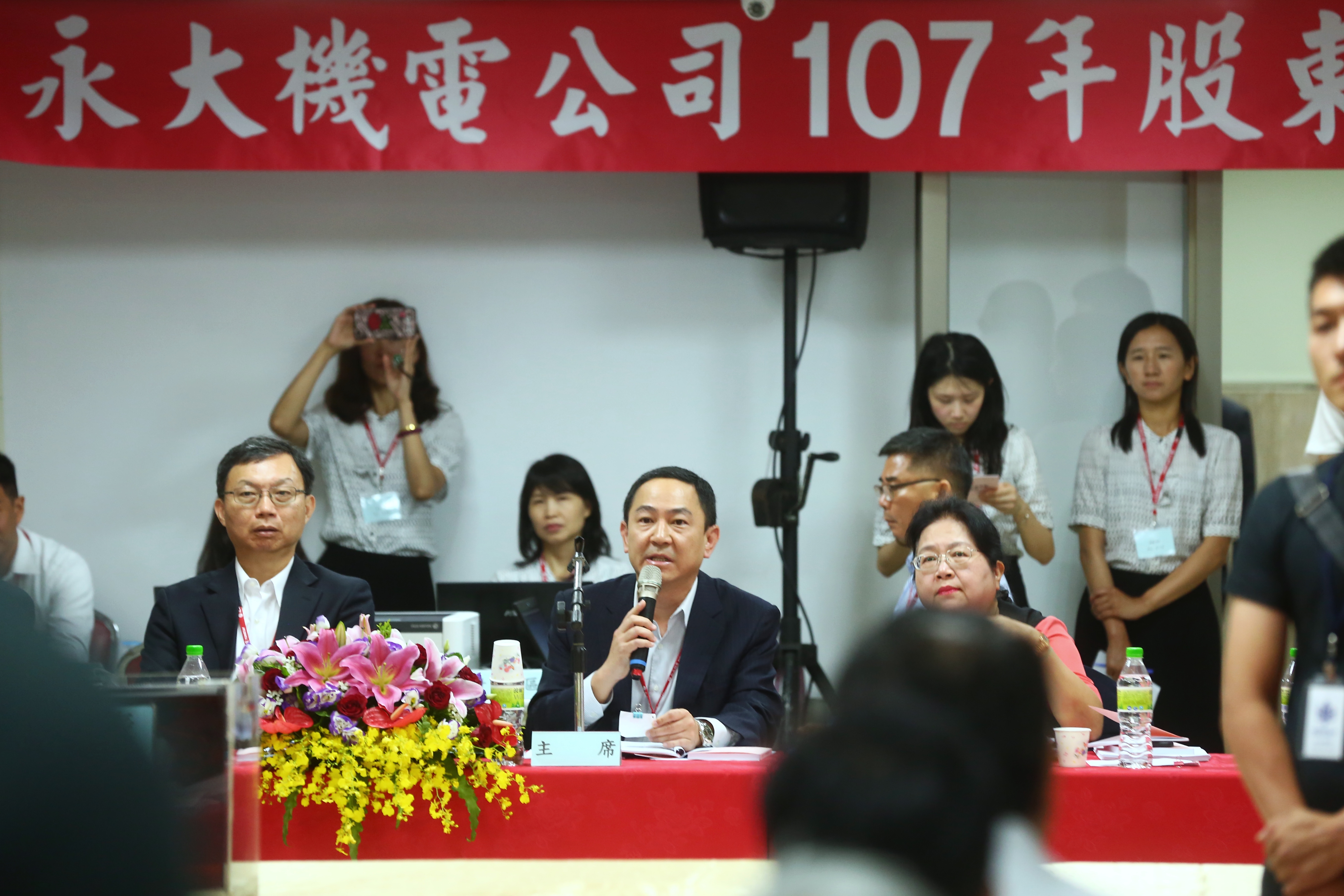 永大機電董事長許作立請假，由兒子許瑞鈞（拿麥克風者）代理主持會議。