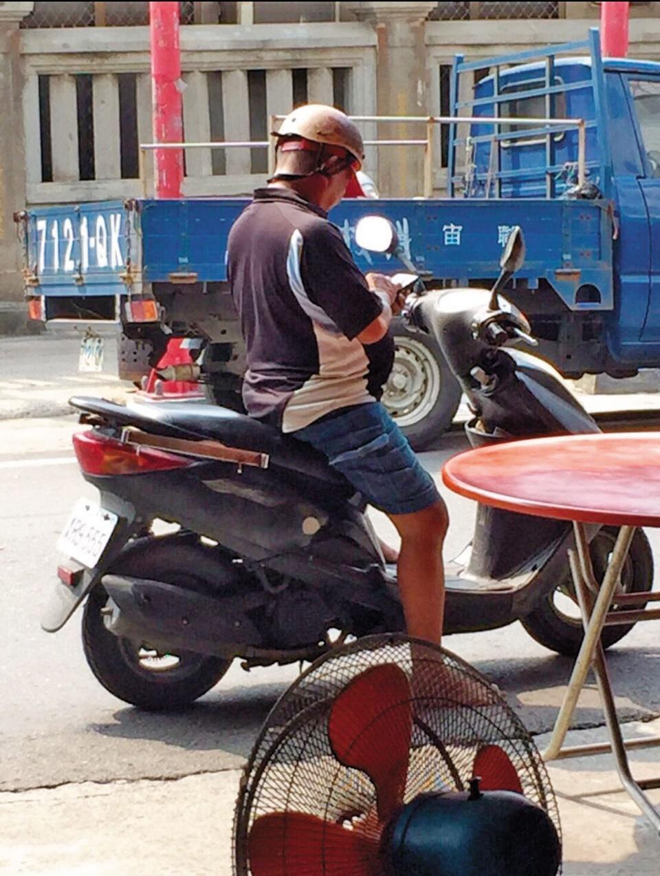 陳清敏在路邊騎機車抓寶的畫面,成為許多北港人的記憶。(陳信宏提供)