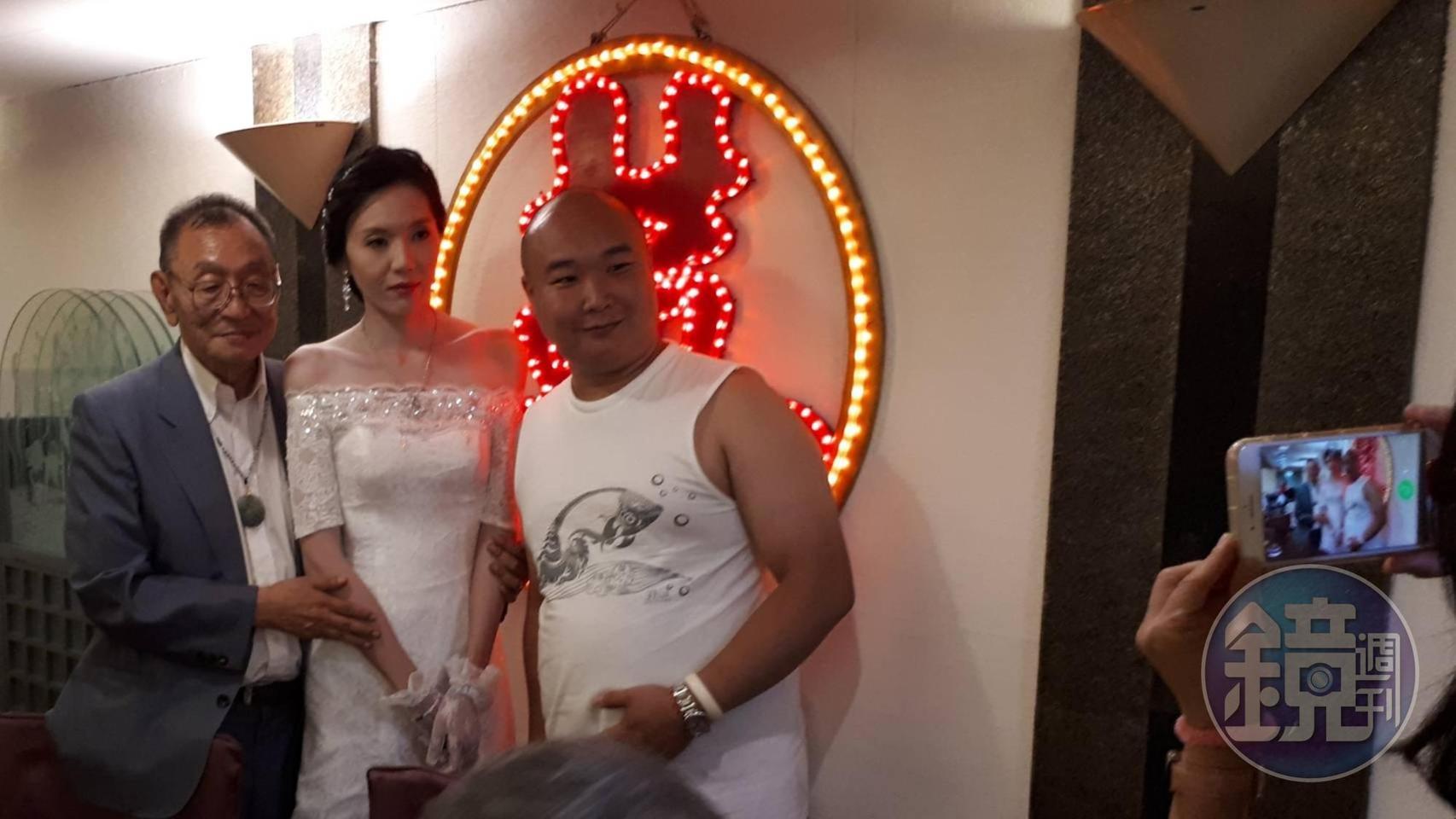 一位大陸人(右)慕名前來董念台的婚宴會場,搶著與董氏夫妻合照。