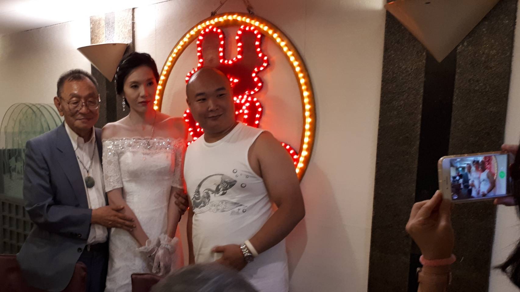 一位大陸人（右）慕名前來董念台的婚宴會場，搶著與董氏夫妻合照。