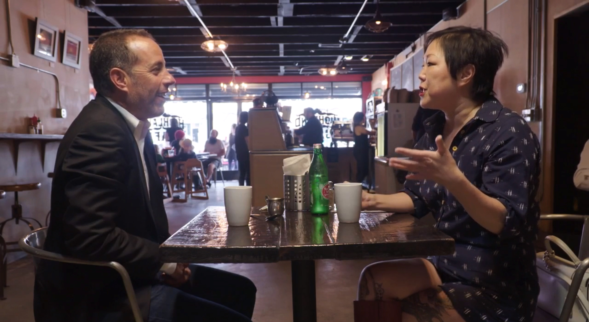 知名喜劇演員傑瑞史菲德（左）在趙牡丹年輕時就看出她有天才，圖為傑瑞邀她參加節目《諧星乘車買咖啡》的畫面。（翻攝自jalopnik.com）