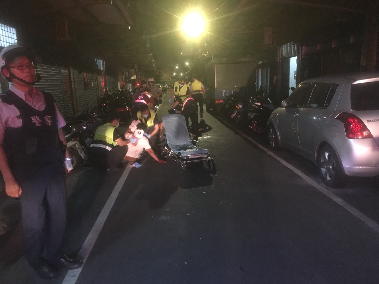 警消將被砍的傷者送醫救治。（翻攝畫面）