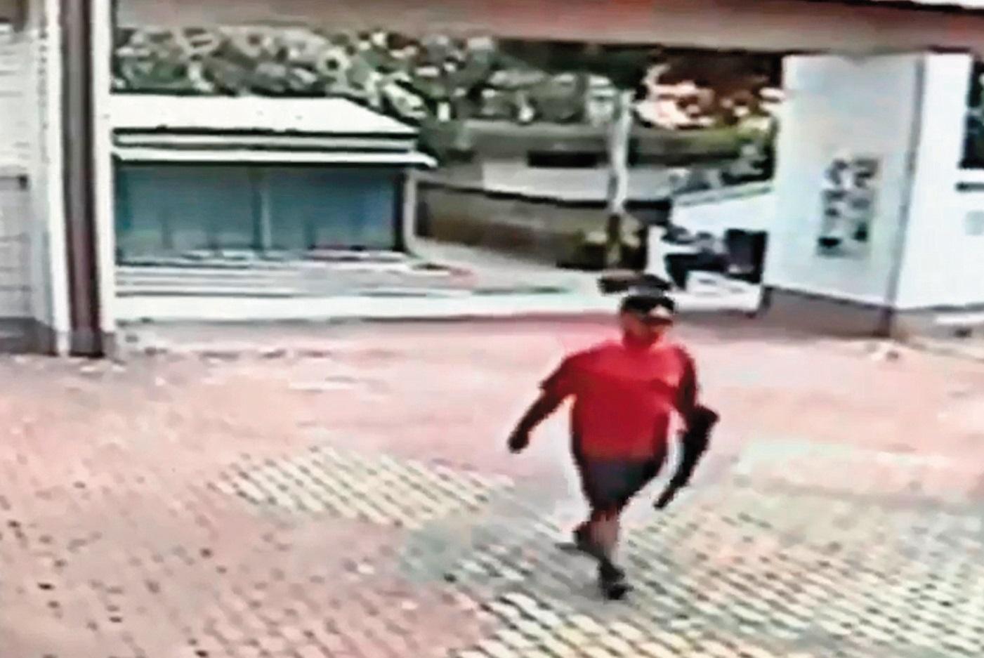 江宇倫身材壯碩被行政人員一眼認出,手上還拿著長槍,大搖大擺地從校門口走進來。(翻攝畫面)