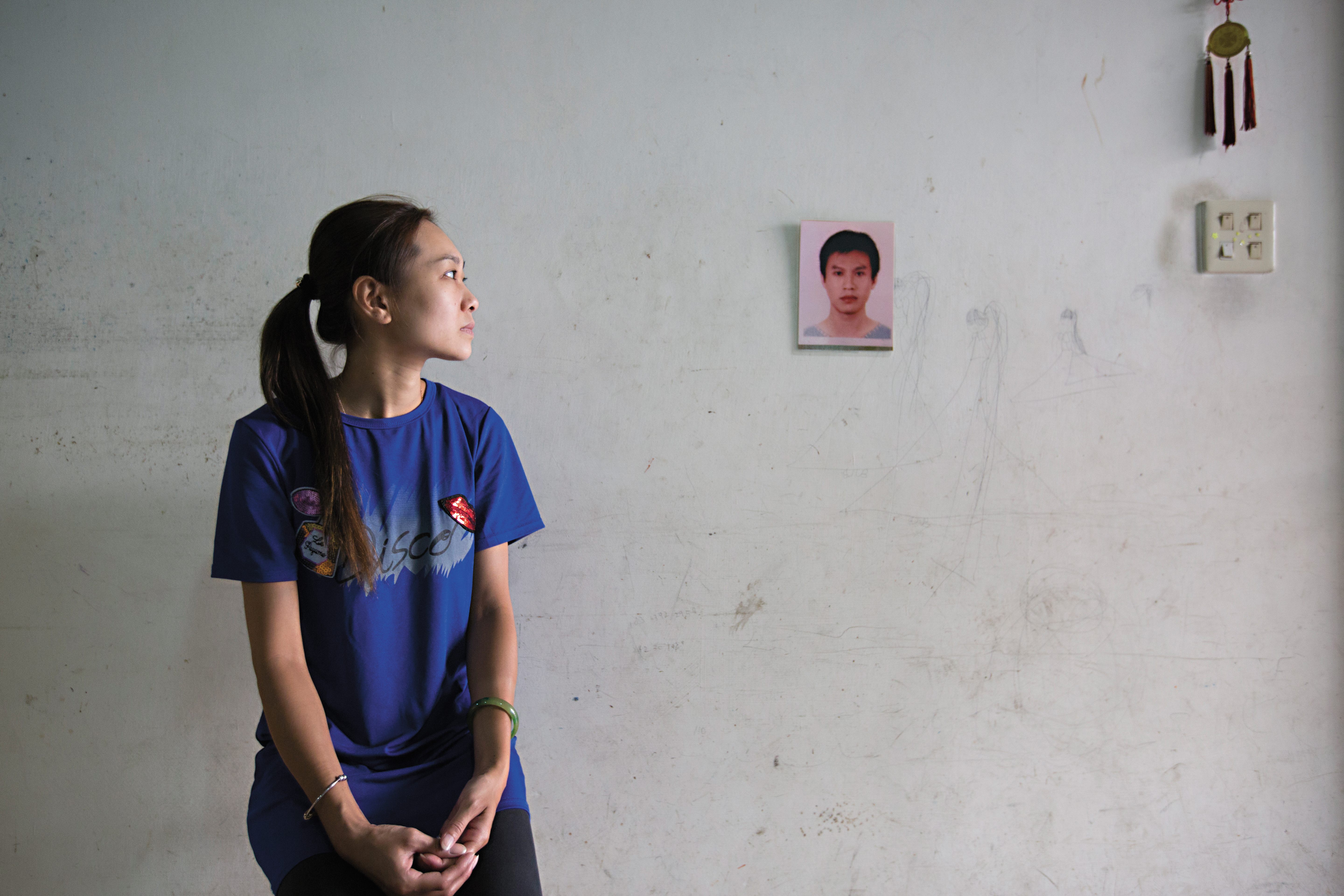 呂智偉生前不常照相，留下的遺照僅手掌大小。鄭淨蓮靜靜地看著老公遺照。