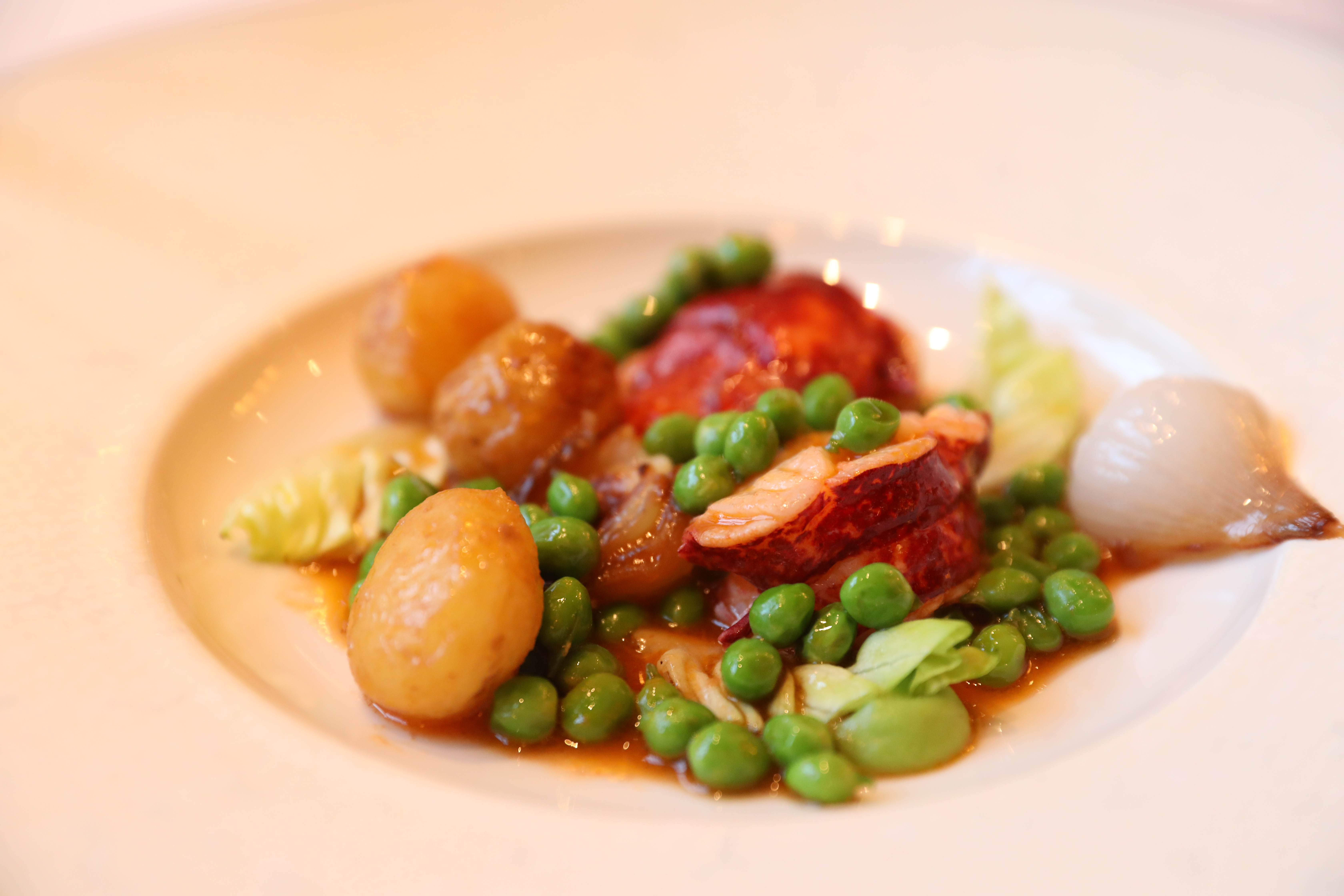 有藍龍蝦、小洋蔥、青豆的主菜，是由服務生在客人眼前組合而成。（Tasting Menu菜色）