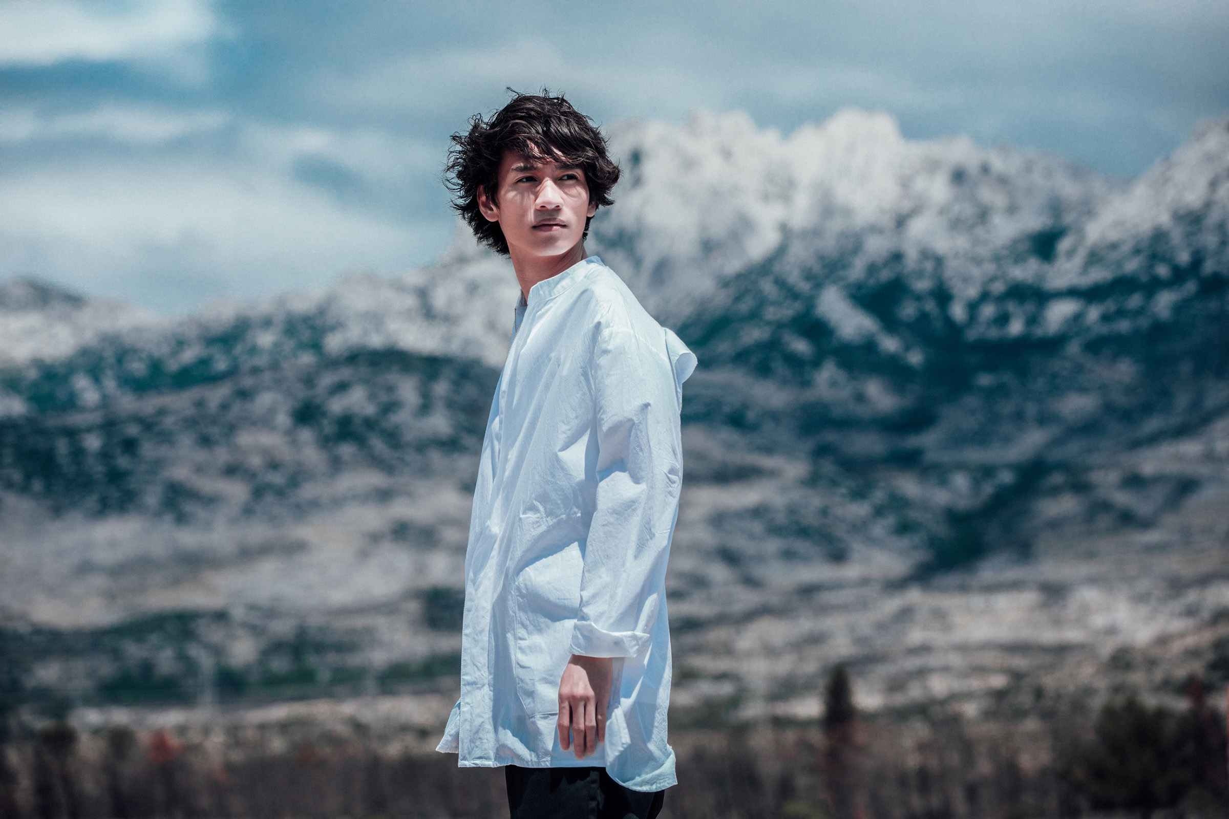 柯智棠站上約2、3層樓高的岩石彈唱，頭上有著空拍機盤旋，可以站穩的地方又非常小，他努力保持平衡。（好多音樂提供）