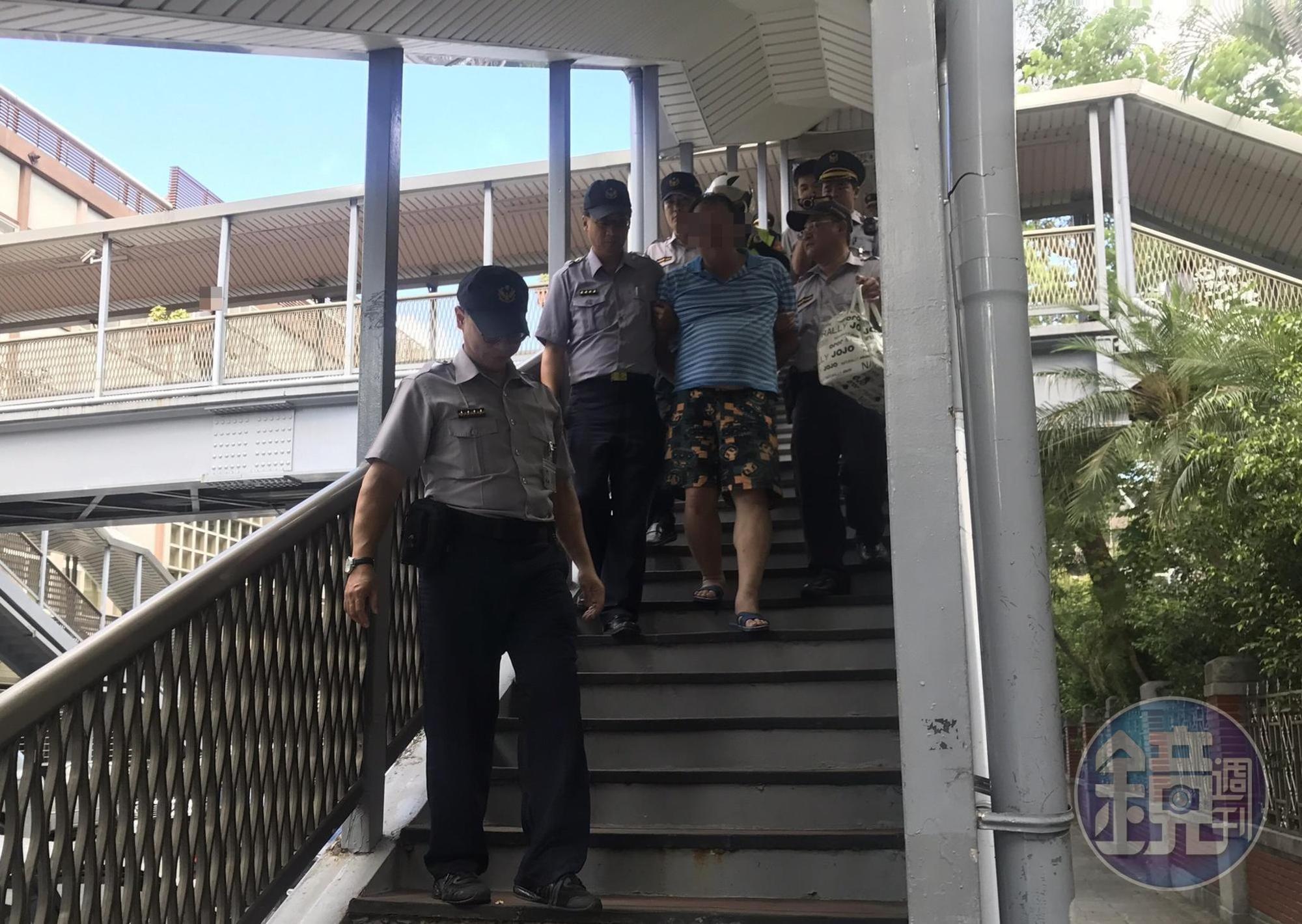 一名楊姓男子疑似酒醉後,跑到立法院青島東路上的天橋揚言自殺,被保六駐警與中正一分局員警合力制伏,帶回警局保護管束。(民眾提供)