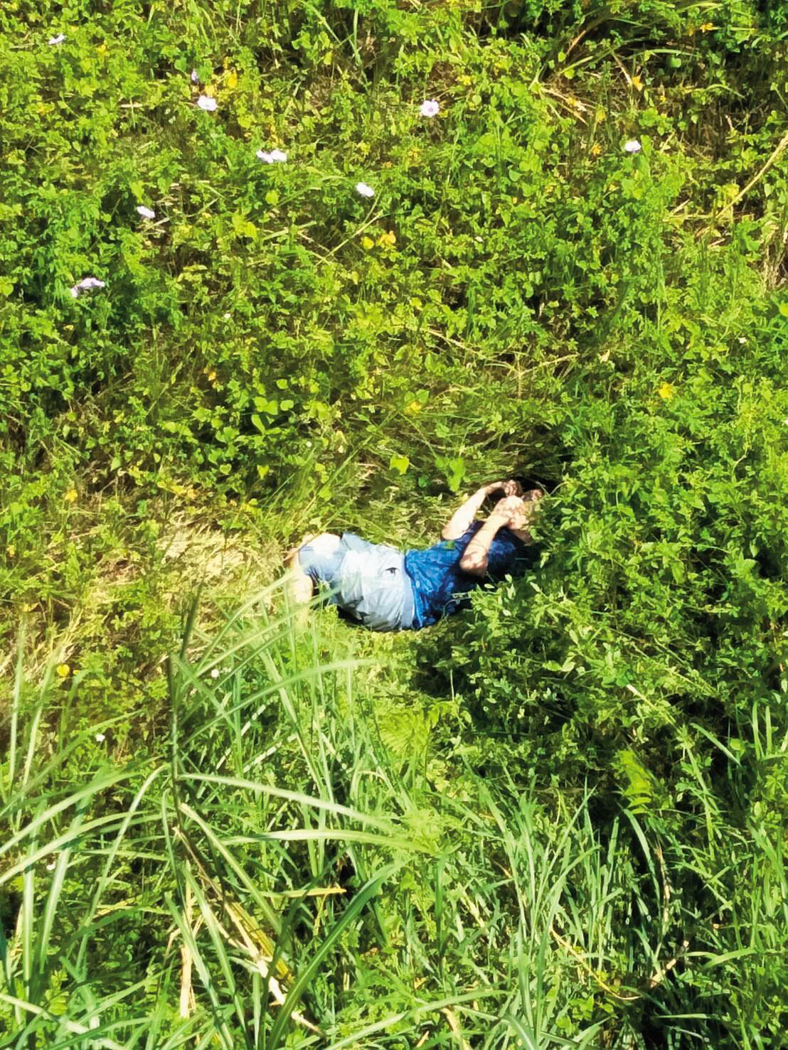 莊嫌跳橋後毫髮無傷,死命往茭白筍田跑,直到精疲力竭才躺在地上,等警察來抓。(翻攝畫面)