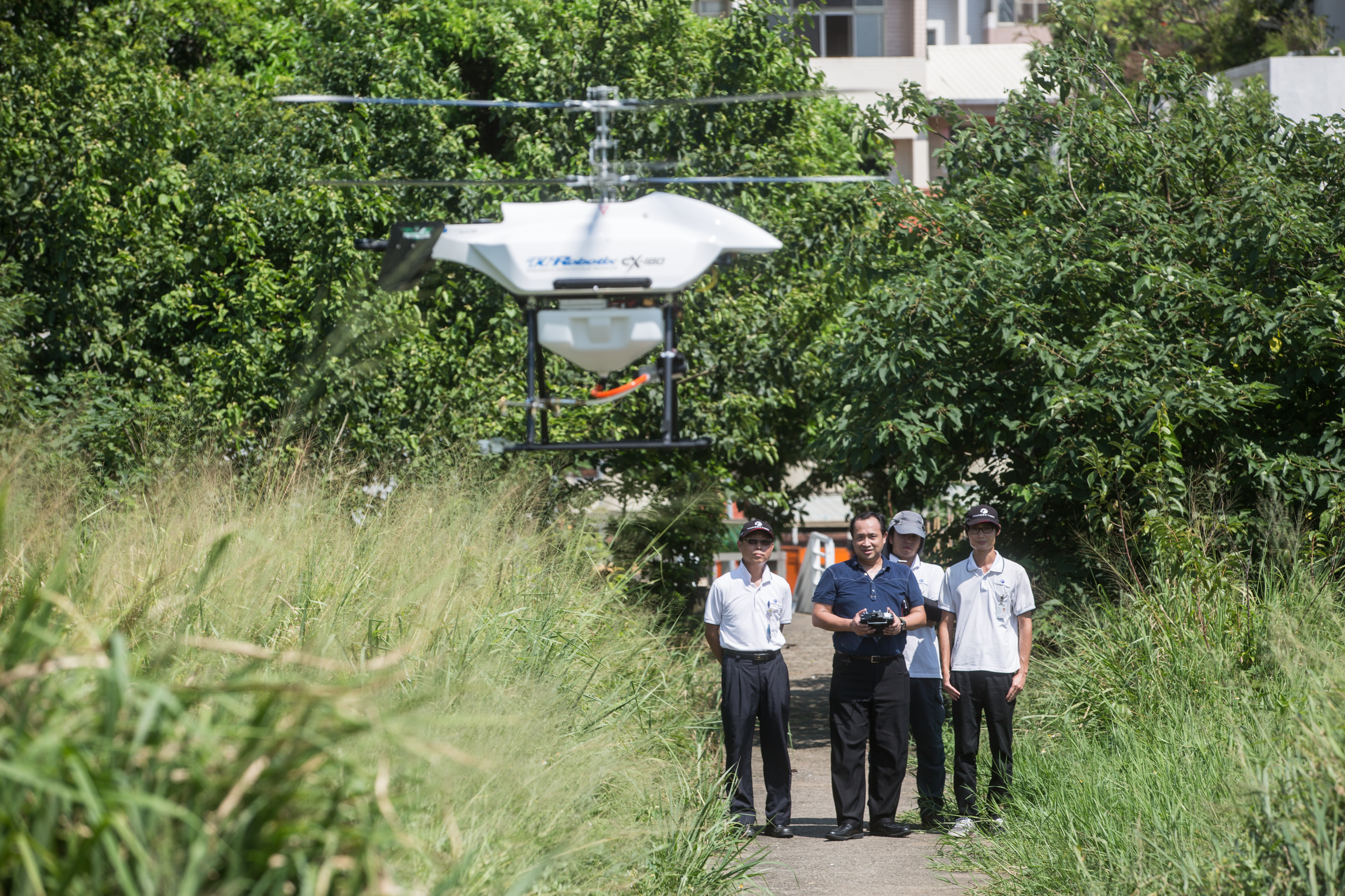 陳冠如（左2）近年投資雷虎科技，為展示自家智慧無人載具，親自試飛無人機。