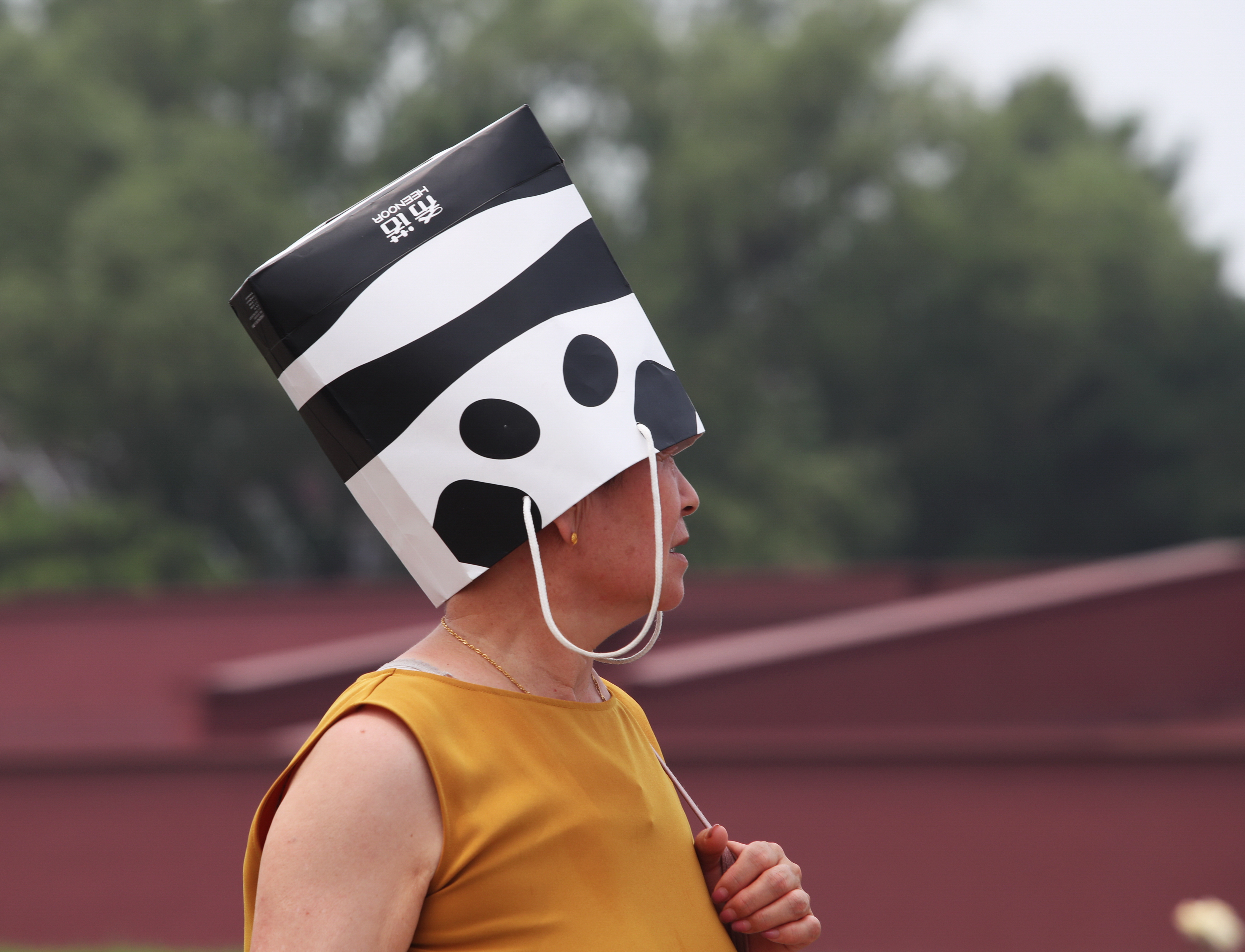 北京天安門民眾頭頂紙袋抵擋酷暑。（東方IC）