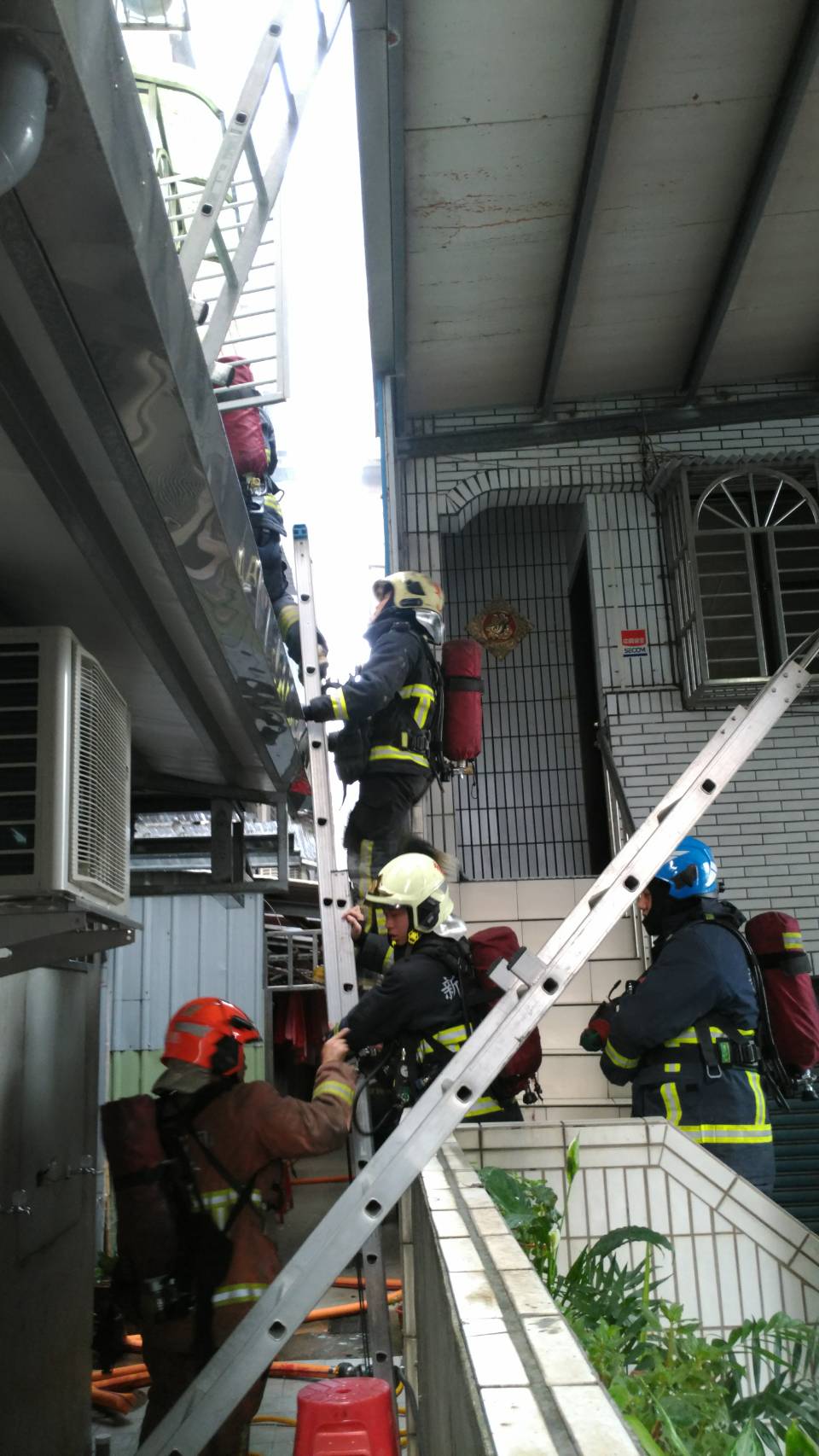 消防人員搭梯欲進入火場搶救傷者。(翻攝畫面)
