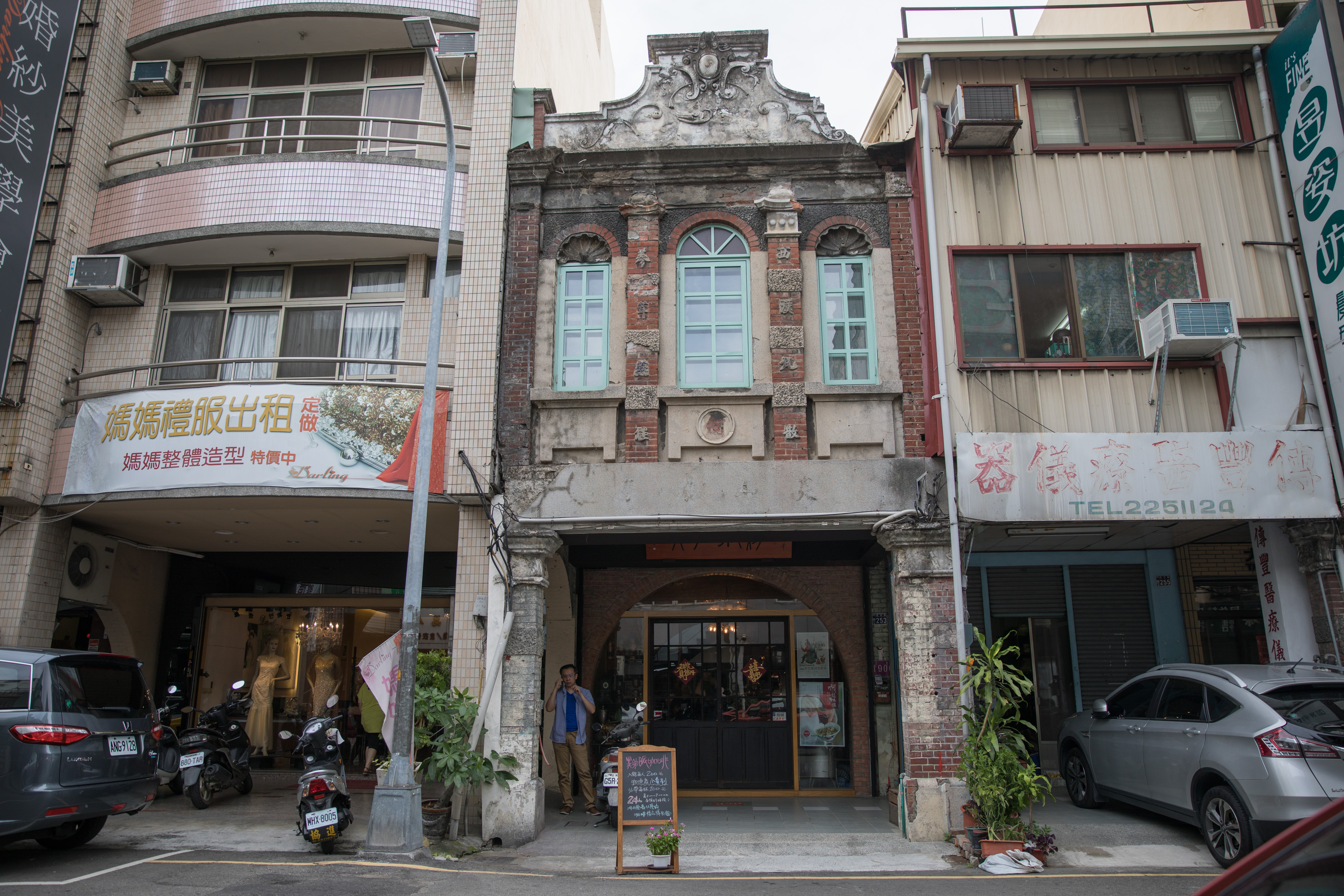 夾在兩間屋子中央的，就是保存百年建築的「黝脈咖啡」