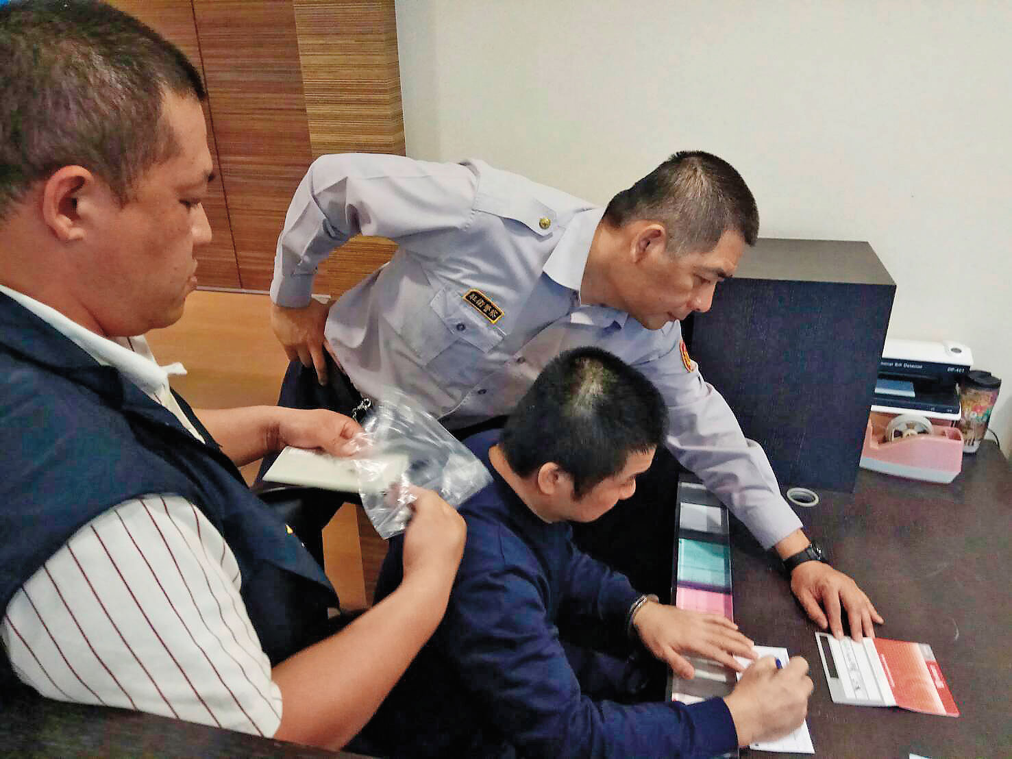 詐騙祖師爺朱志偉（黑襯衫者），和日本黑幫結合，化身成種子教官行騙，為了爭取官司輕判，吐出300萬元賠償被害人。（讀者提供）