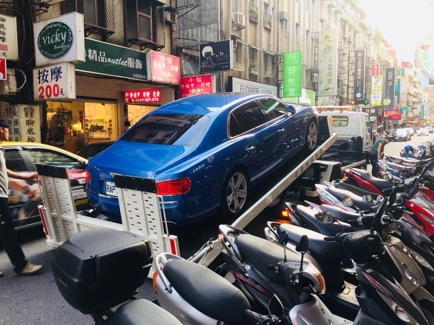 因避震器「爆炸」冒煙而被原廠拖離現場的賓利車。（讀者提供）