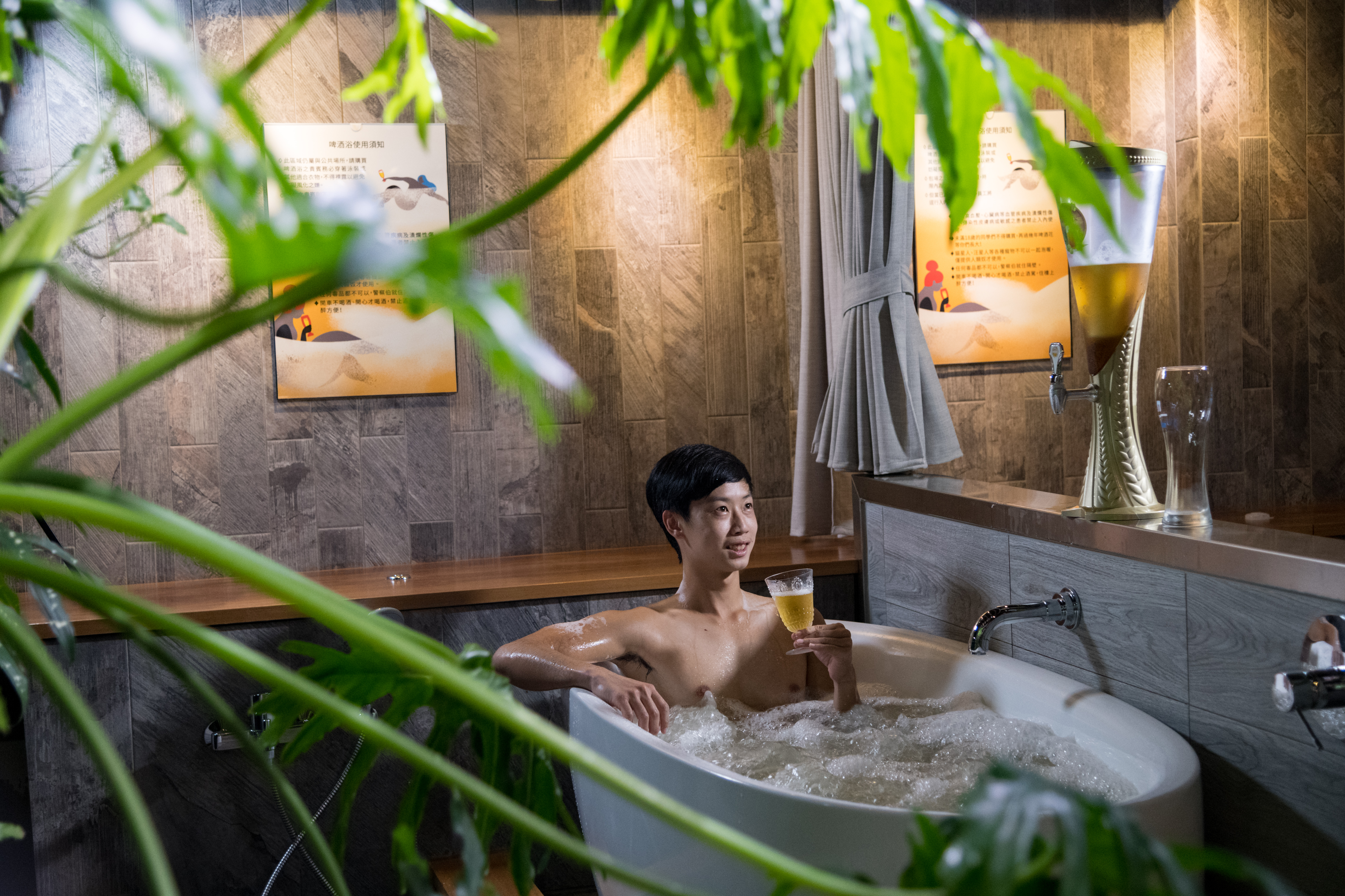 「啤酒花大酒店」打造啤酒浴場，一面泡在啤酒海，一面喝生啤酒，酣暢滋味寫在臉上。