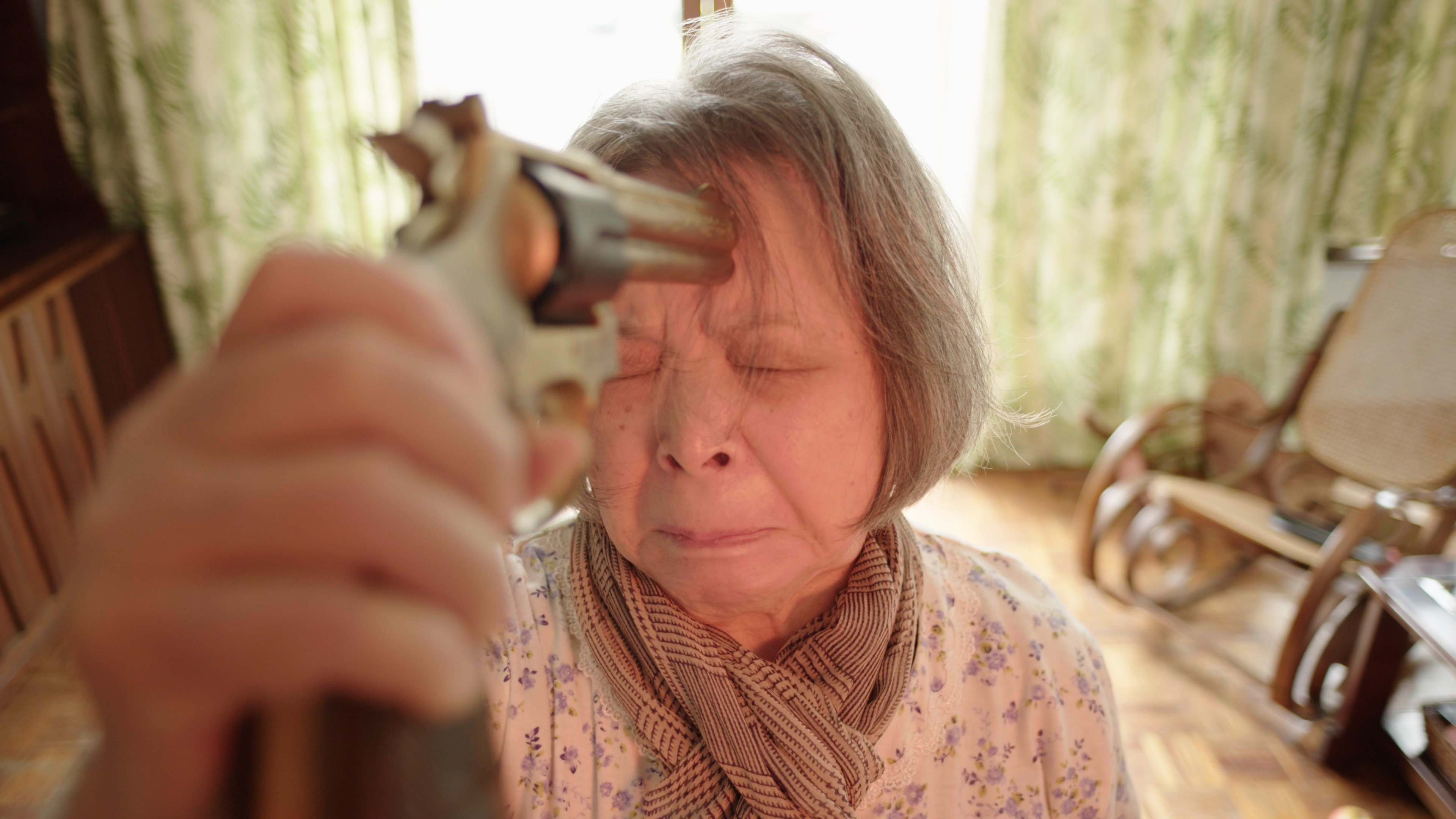 靈堂前梅芳舉起水槍佯裝自殺。（公視提供）