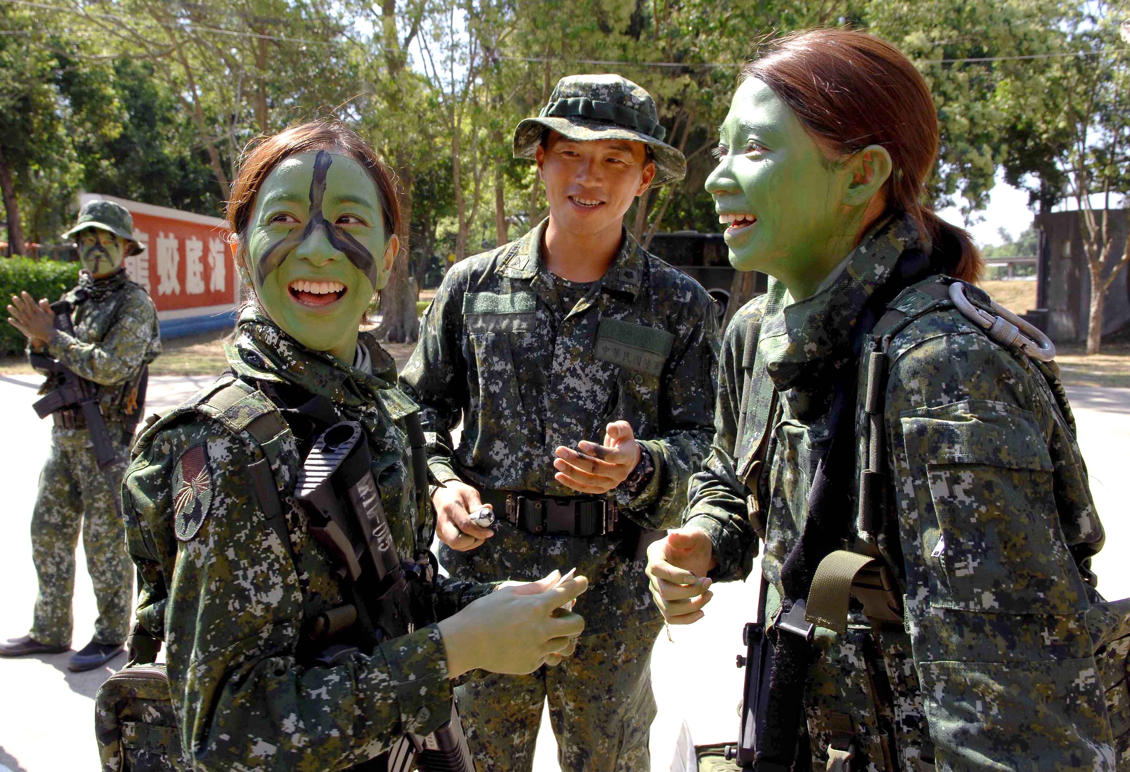 曾智希與凱莉執行「模擬任務」，在對方臉上塗抹偽裝用的迷彩妝。（華視提供）