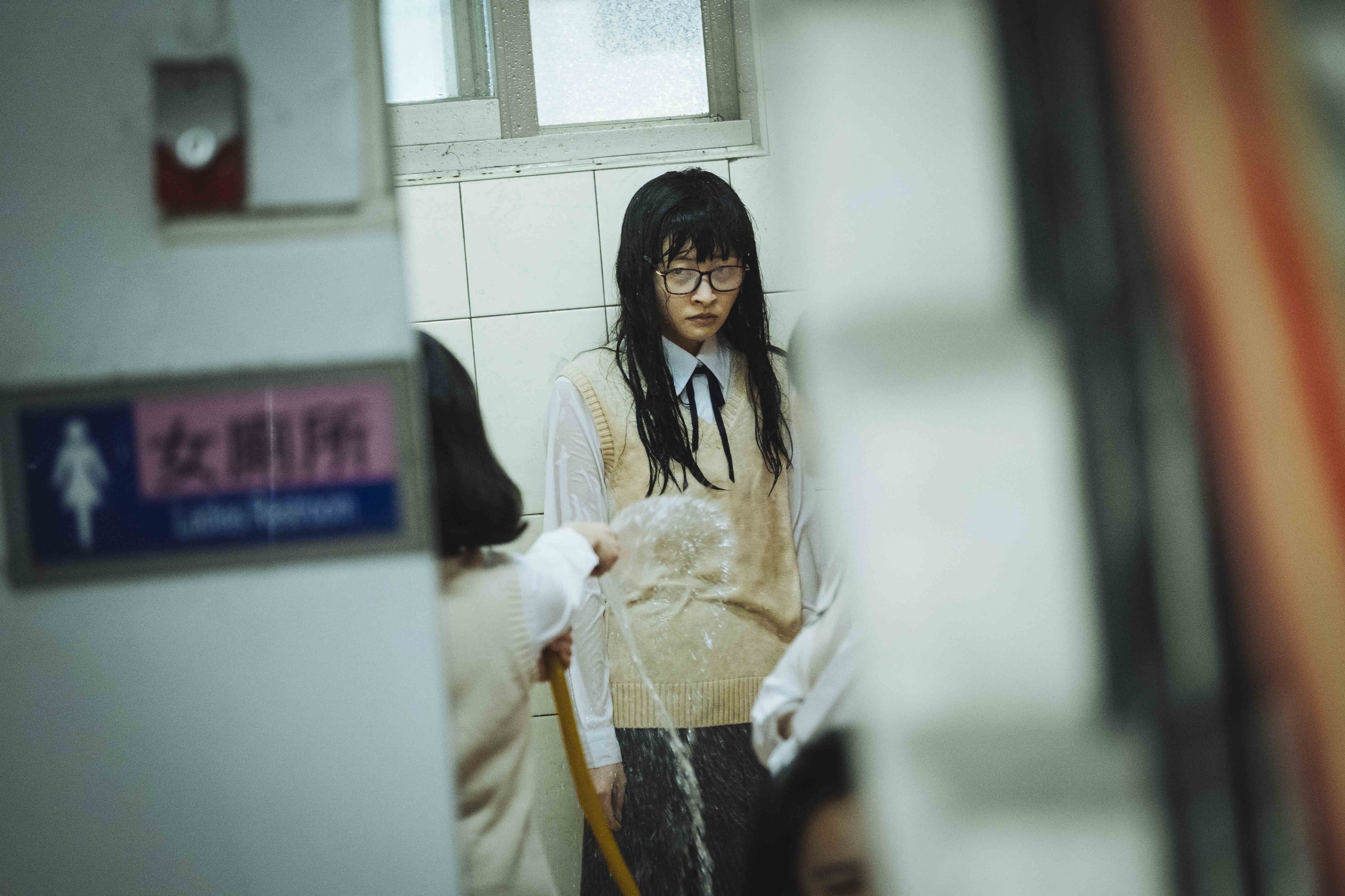 李亞臻在片中歷經各種慘事,被人用水管噴溼全身。(華影國際提供)