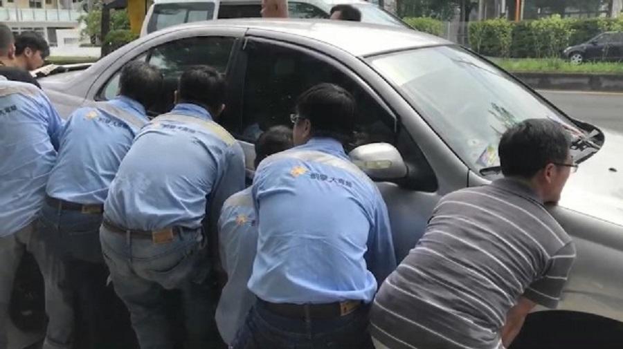 十多名壯漢在轎車兩邊合力抬車。（警方提供）