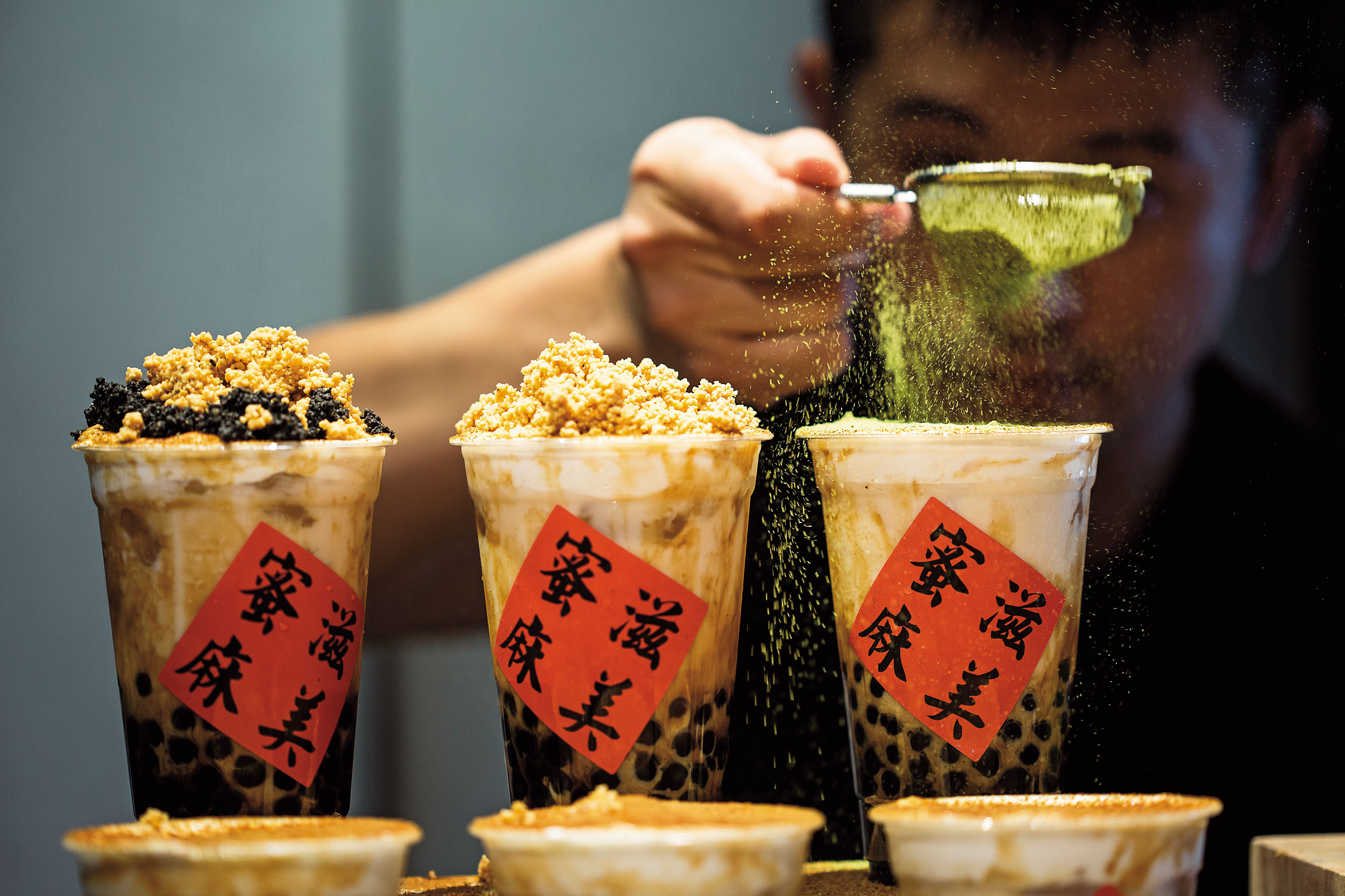 第三代陳永安在一中街開飲料店「蜜滋麻美」，將黑糖珍奶撒上花生、芝麻粉或抹茶粉，打造成可以喝的甜點。（奶蓋粉圓黑糖鮮奶，50元／杯）