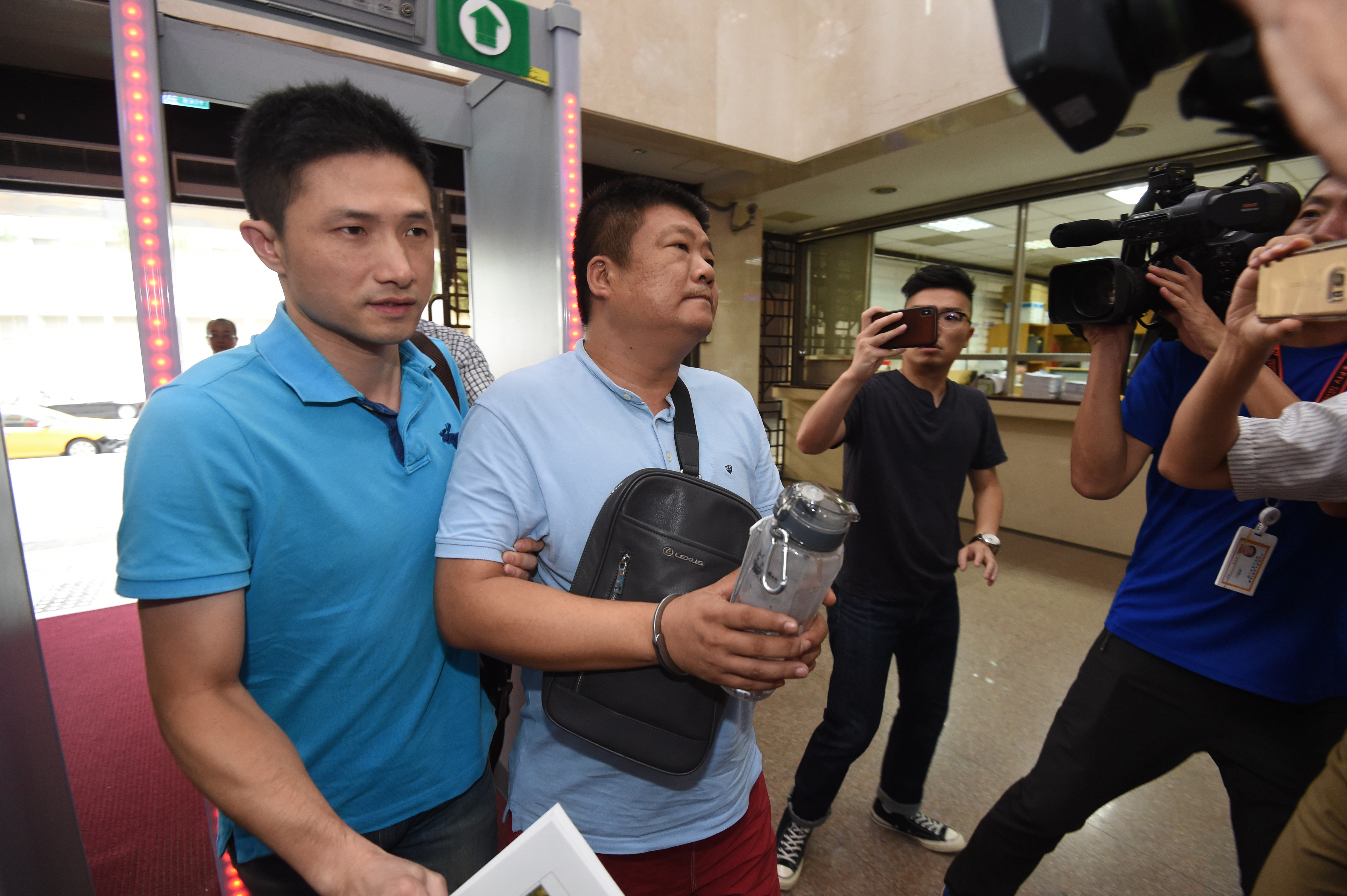 松菸大樓內的富邦建設遭人3度槍擊，警方逮捕疑是藏鏡人的松聯幫「華哥」柯榮華（左2）。