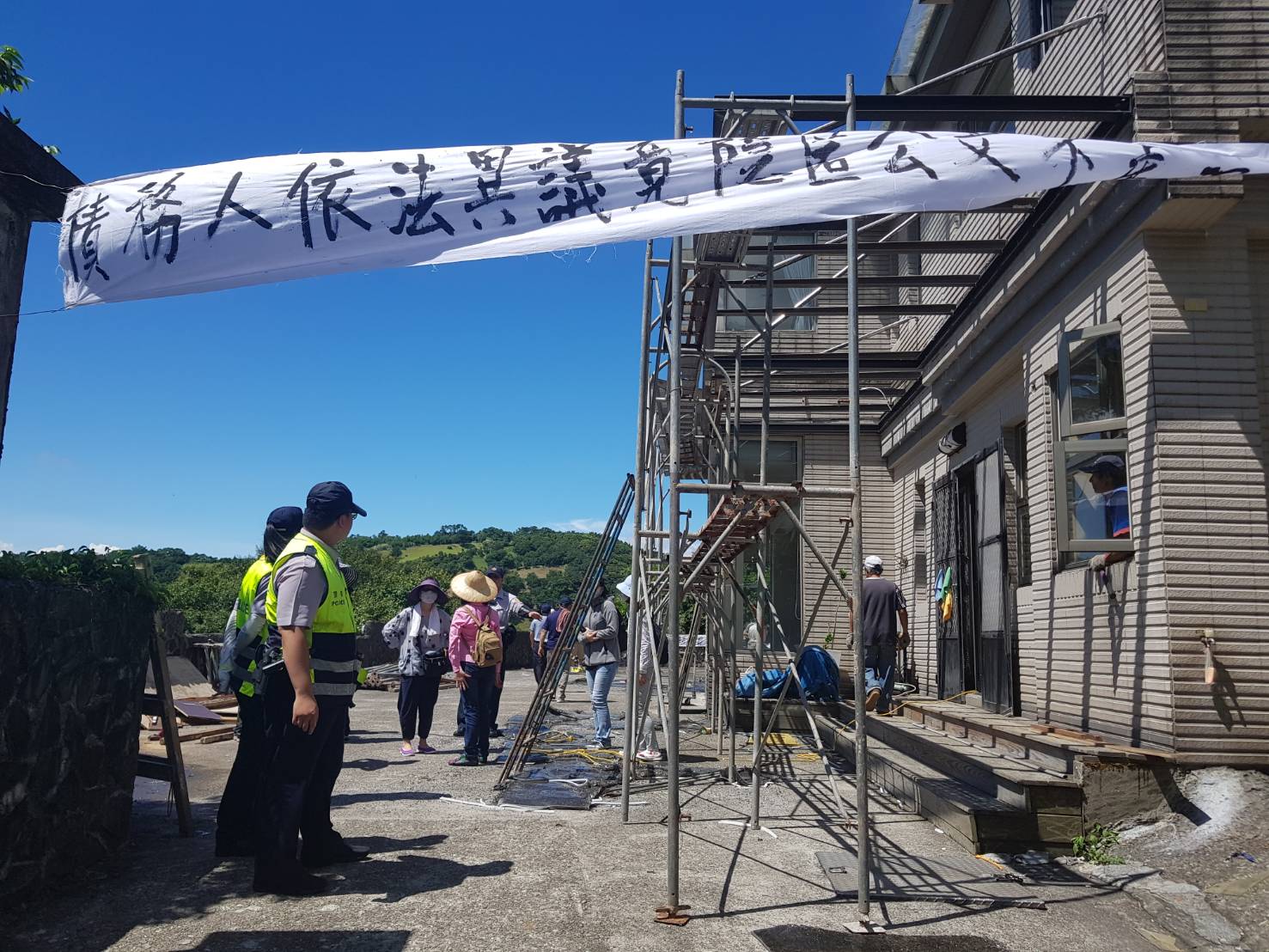 警方守在透天厝入口處,以妨害公務為由,要求記者不得靠近。