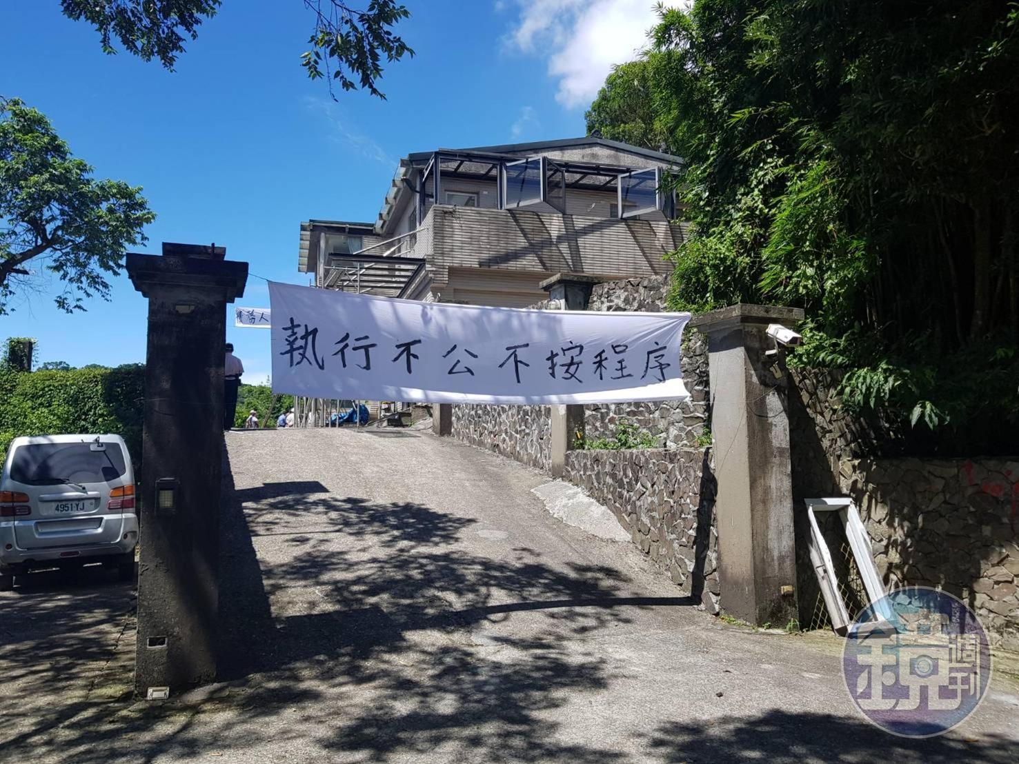 屋主質疑拆屋程序有瑕疵，拉起白布條抗議。