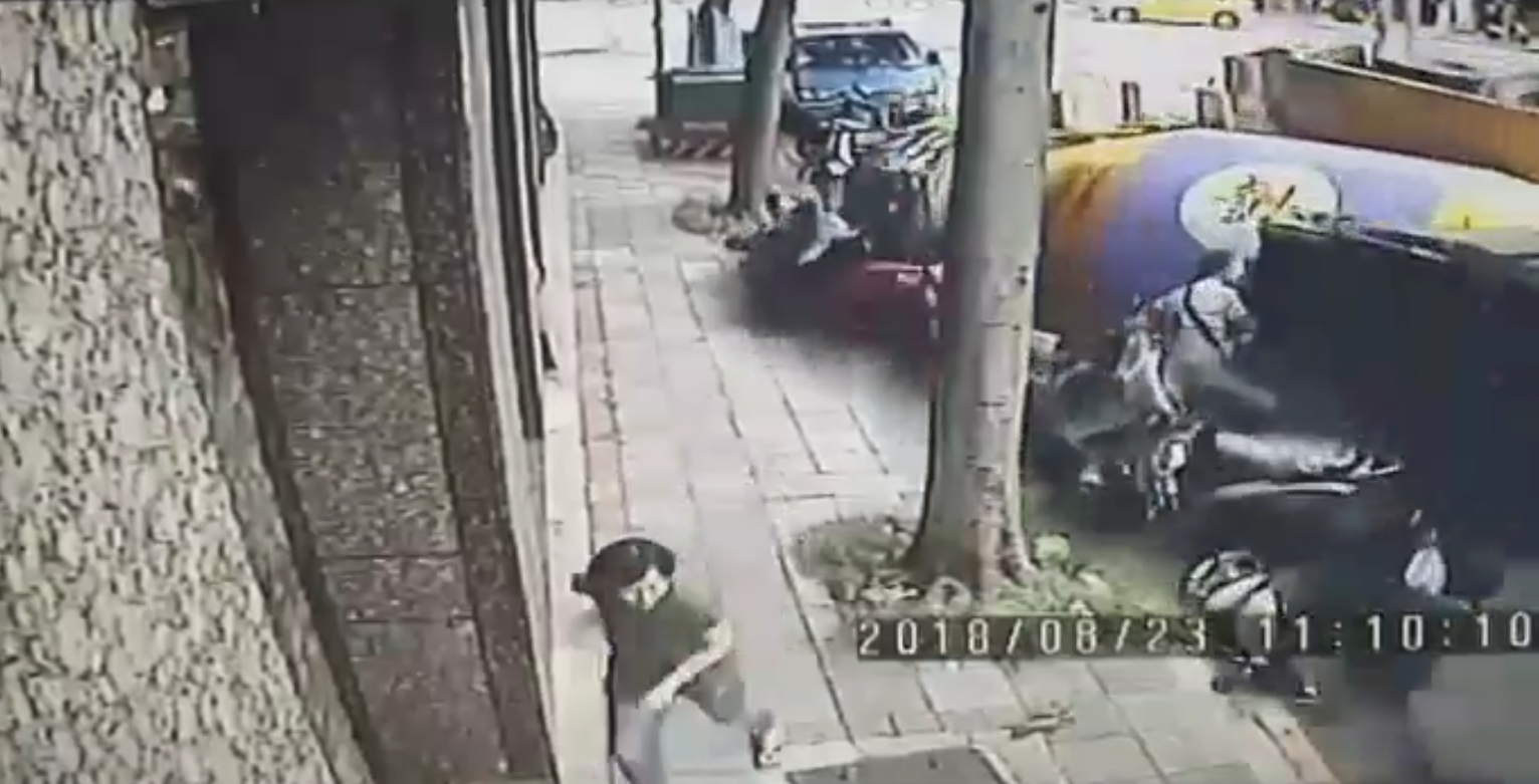 因過彎失速的水泥車撞上停靠一旁的機車以及自小貨車，所幸貨車司機反應機敏逃過一劫，人行道上的婦人也趕緊閃避。（翻攝畫面）