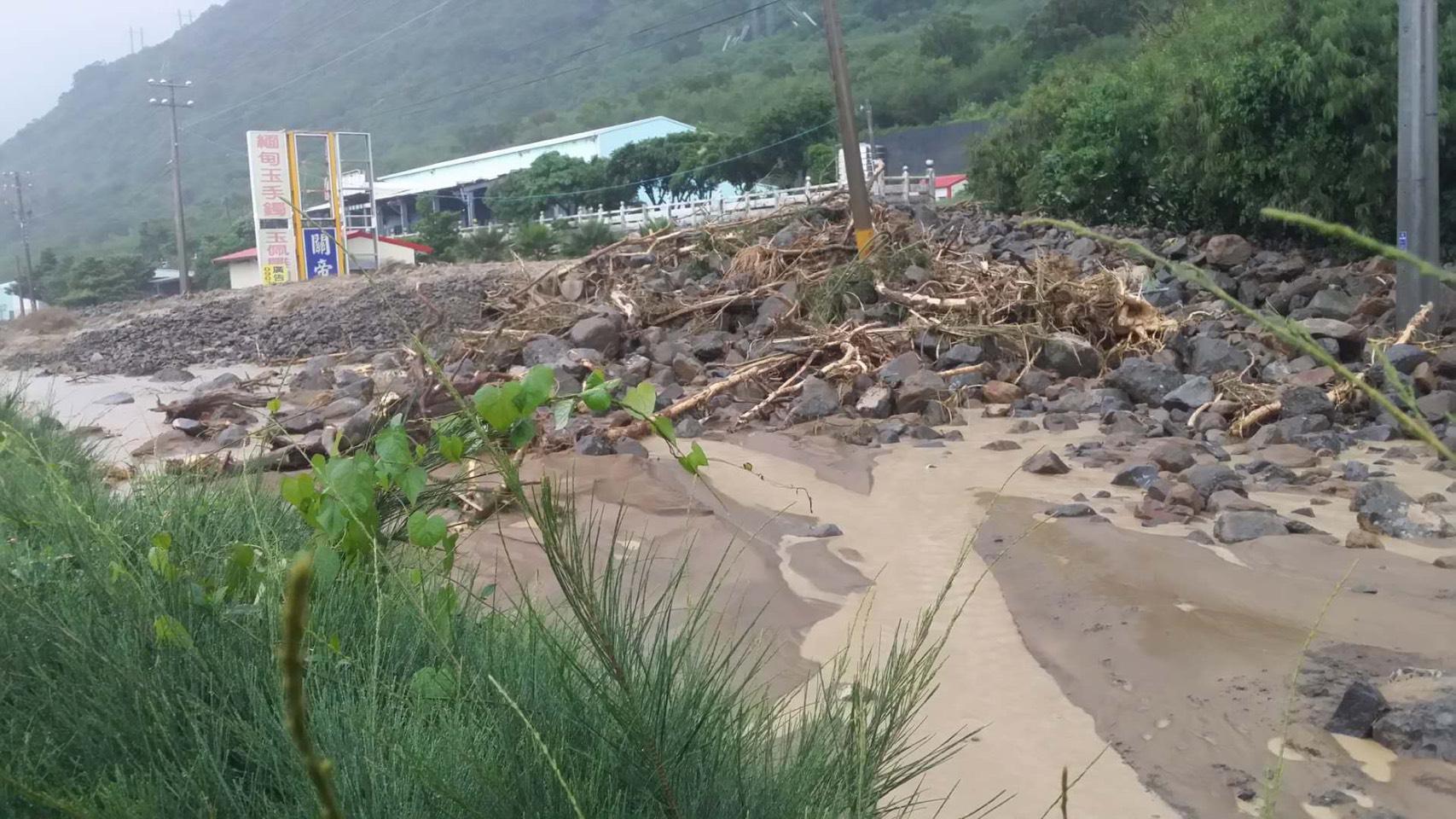 大量黃泥石塊堆積馬路上,人車無法通行,偏偏屏東政府卻宣布正常上班課,引發民怨。(翻攝網路)