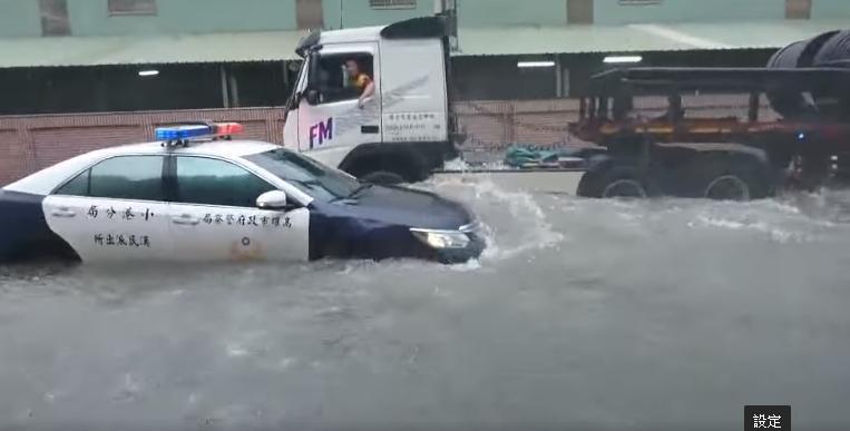警車受困水中,大卡車一經過,水壓讓警車在水中飄移。(翻攝自爆料公社)