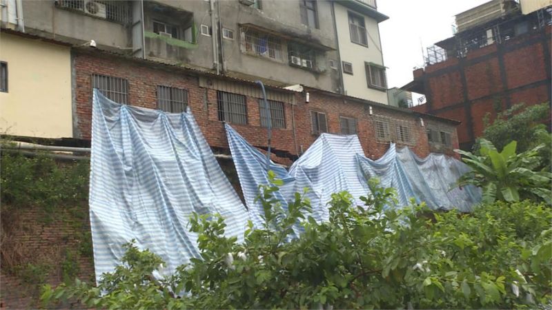 區公所趕緊用帆布將後方擋土牆圍起來,避免雨水沖刷,造成災情擴大。(屋主陳小姐提供)