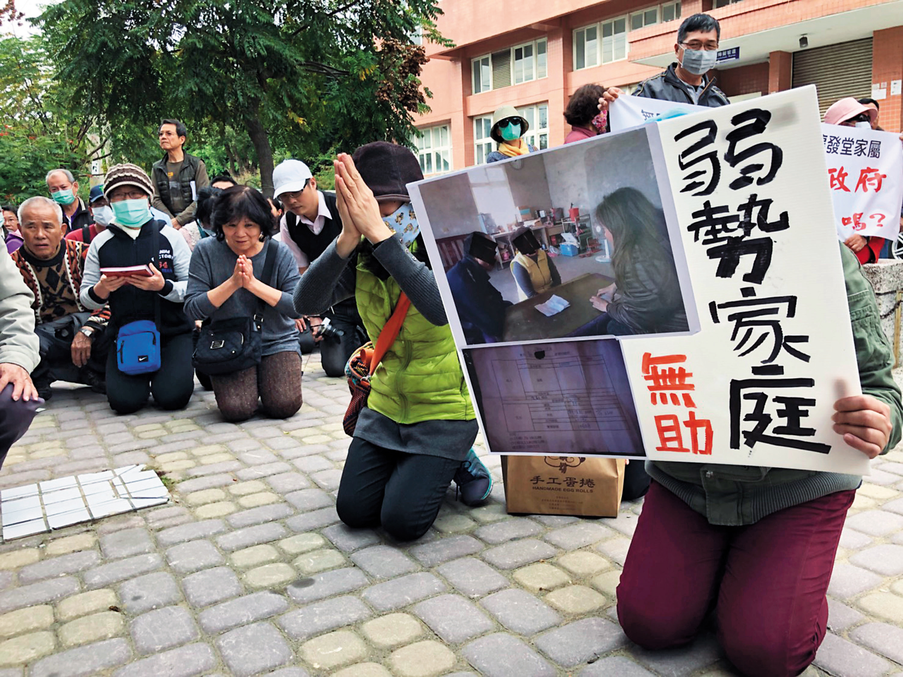 龍發堂爆發疫情、遷出堂眾後，病患家屬曾針對高雄市衛生局處理過程是否得宜下跪陳情，希望政府能解決弱勢家庭面對病患安置上的困難。（中央社）