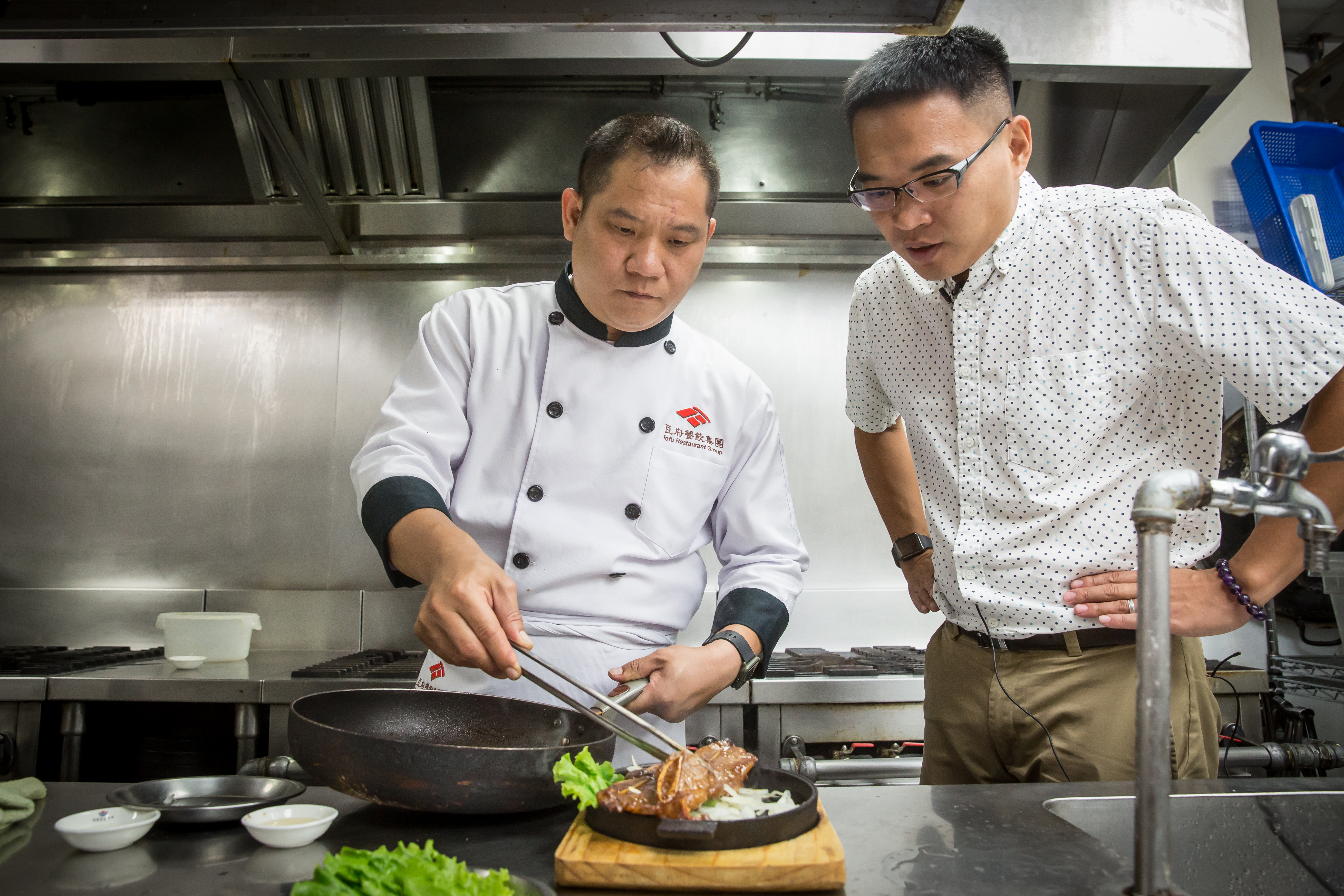 吳柏勳（右）4年前挖角台北華國飯店主廚陳建達（左），2人私底下經常切磋廚藝、討論新菜口味，圖為經典韓式料理BBQ牛小排。