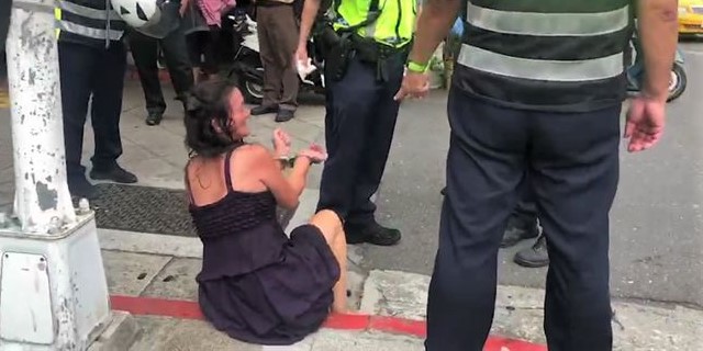 精神異常的曾女遭警方上銬。（翻攝畫面）