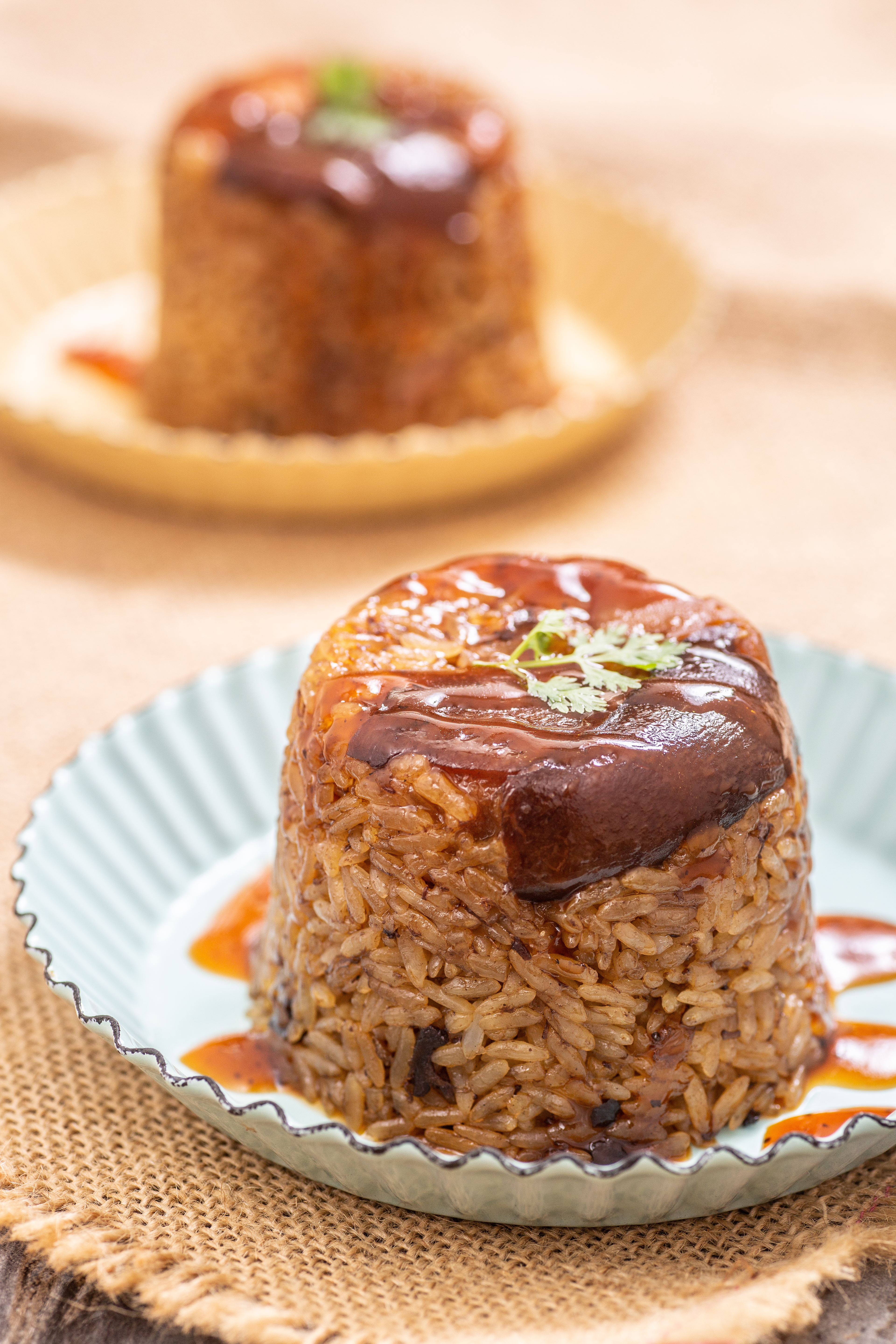 「豬腳筒仔米糕」用蒸好的糯米，趁熱以3：1的滷肉飯汁、椒麻汁拌勻，把料鋪在抹油後的茶杯，壓實放入電鍋蒸就完成。（「椒麻滷汁」，100元／包）