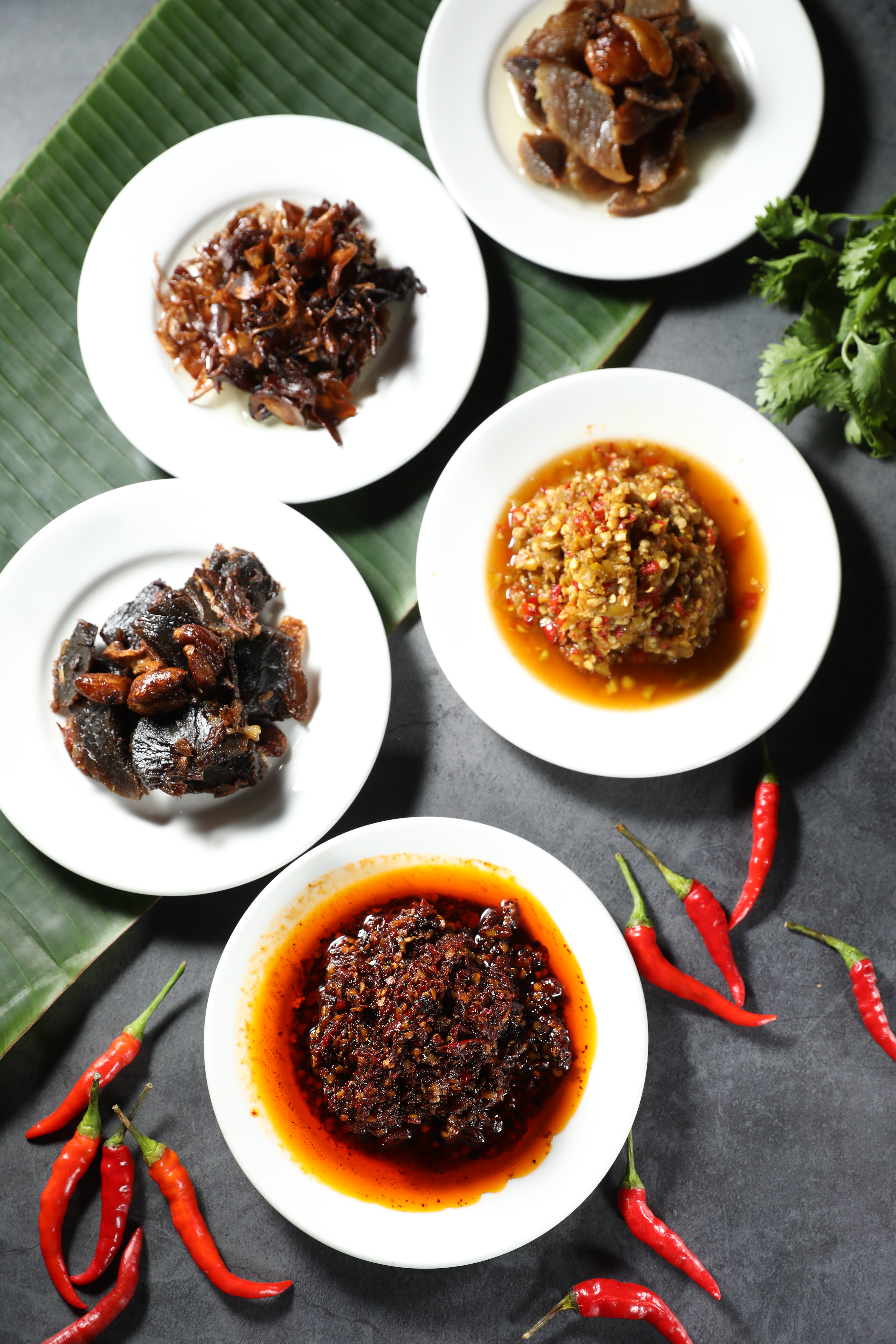 泰廚世家也單賣罐裝加工食品，「麻辣辣椒」（前）加了雲南黑花椒和越南胡椒，還有費工的牛肉乾、用綜合菇蕈慢火炸製的「油雞樅」，都很適合嗜辣之徒。（150元起／小罐）
