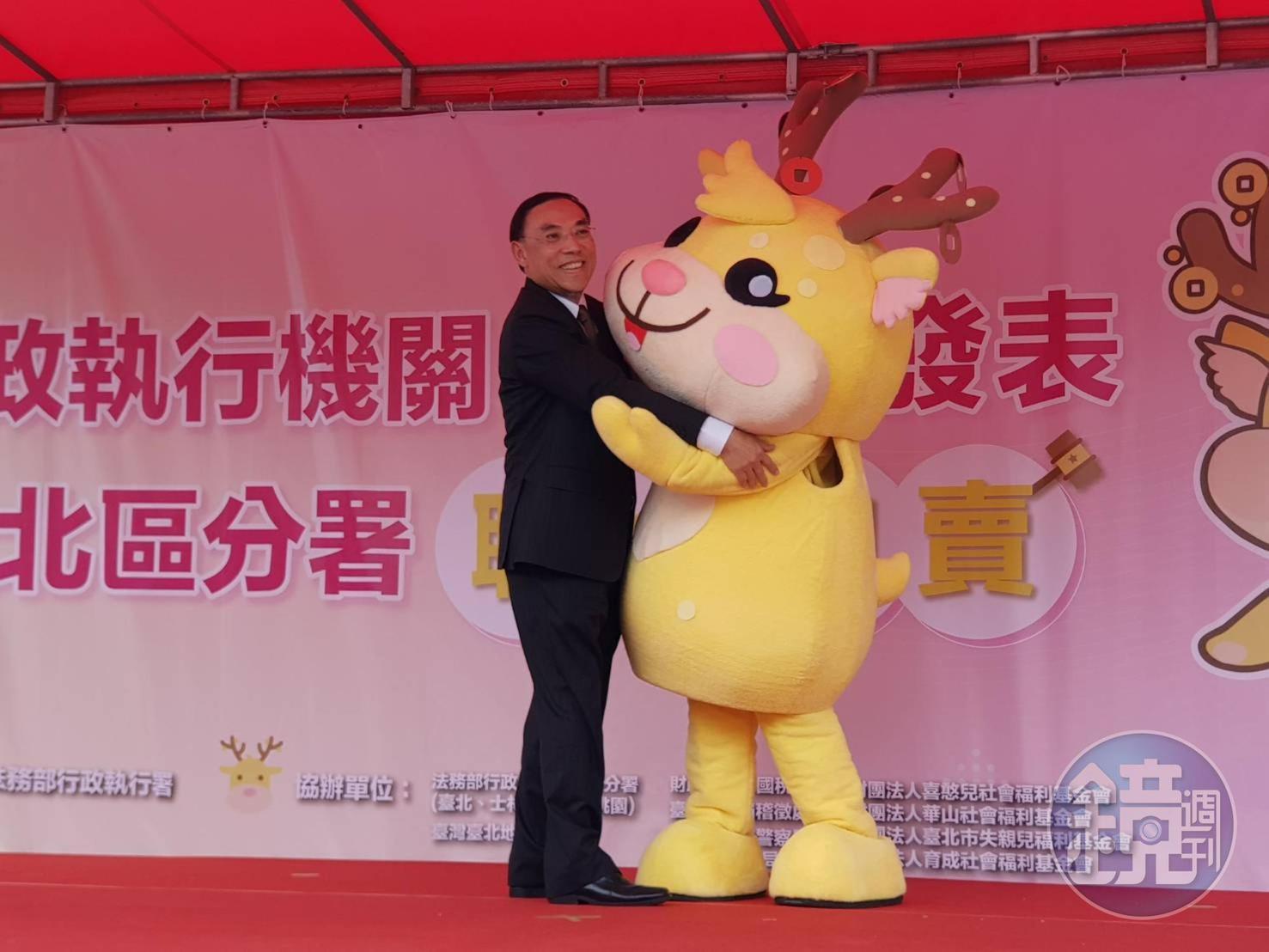 法務部長蔡清祥與行政執行署首度亮相的吉祥物擁抱，吸引民眾搶拍。
