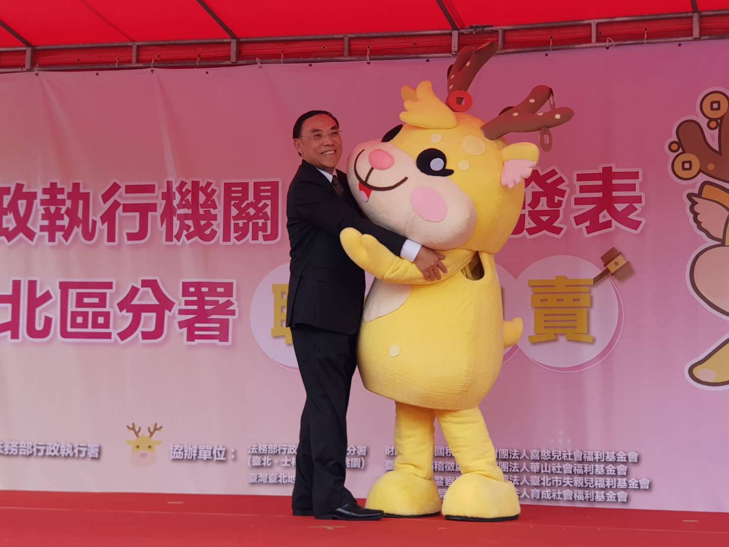 法務部長蔡清祥與行政執行署首度亮相的吉祥物擁抱，吸引民眾搶拍。