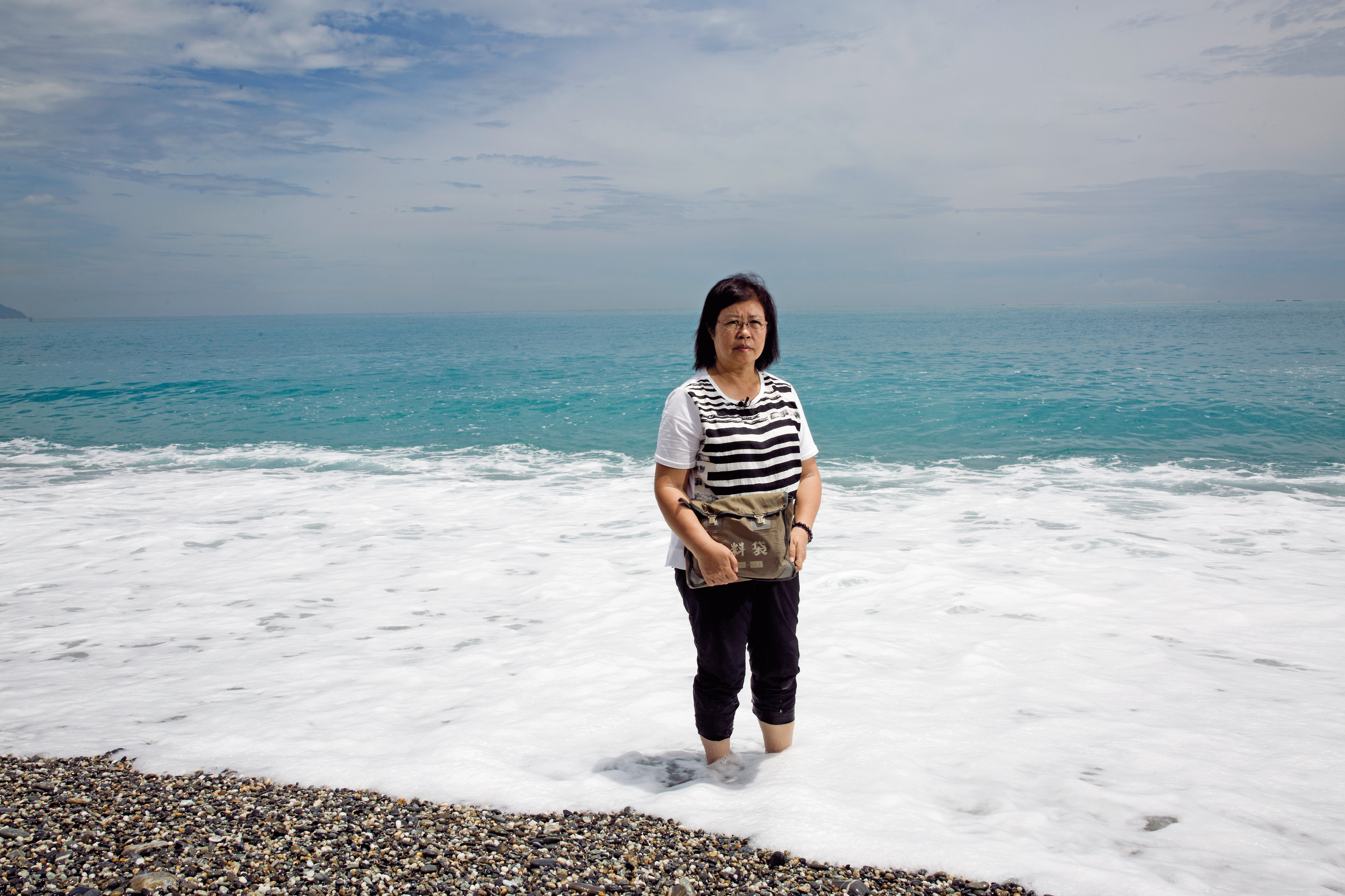 這天，黃媽媽（圖）背著兒子黃國章服役時的軍用資料袋，裡面裝滿兒子的親筆信，來到他生前最愛的花蓮海邊。