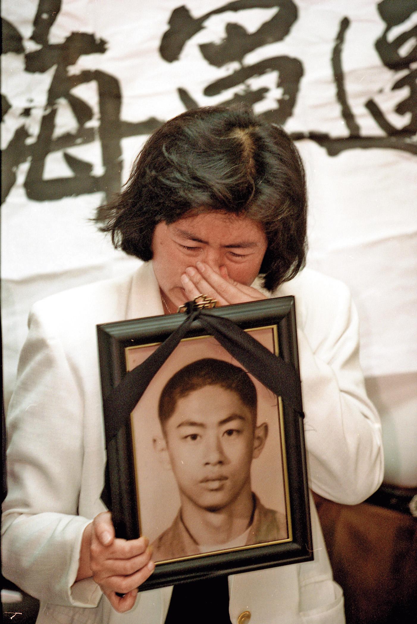 1995年6月，黃媽媽在陳情記者會上拿著兒子的遺照，要求海軍還他兒子來。（中央社）