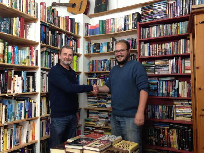 Morris(左)將把書店經營權交給幸運得主Van Heerden。(圖片來源Tivyside Advertiser)
