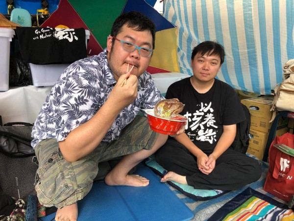 以核養綠公投連署書補件遭中選會拒收，黃士修從進行絕食抗議。PTT八卦版前版主「四叉貓」劉宇今跑到抗議現場，在黃士修旁邊作勢要泡泡麵來吃。（翻攝自劉宇臉書）