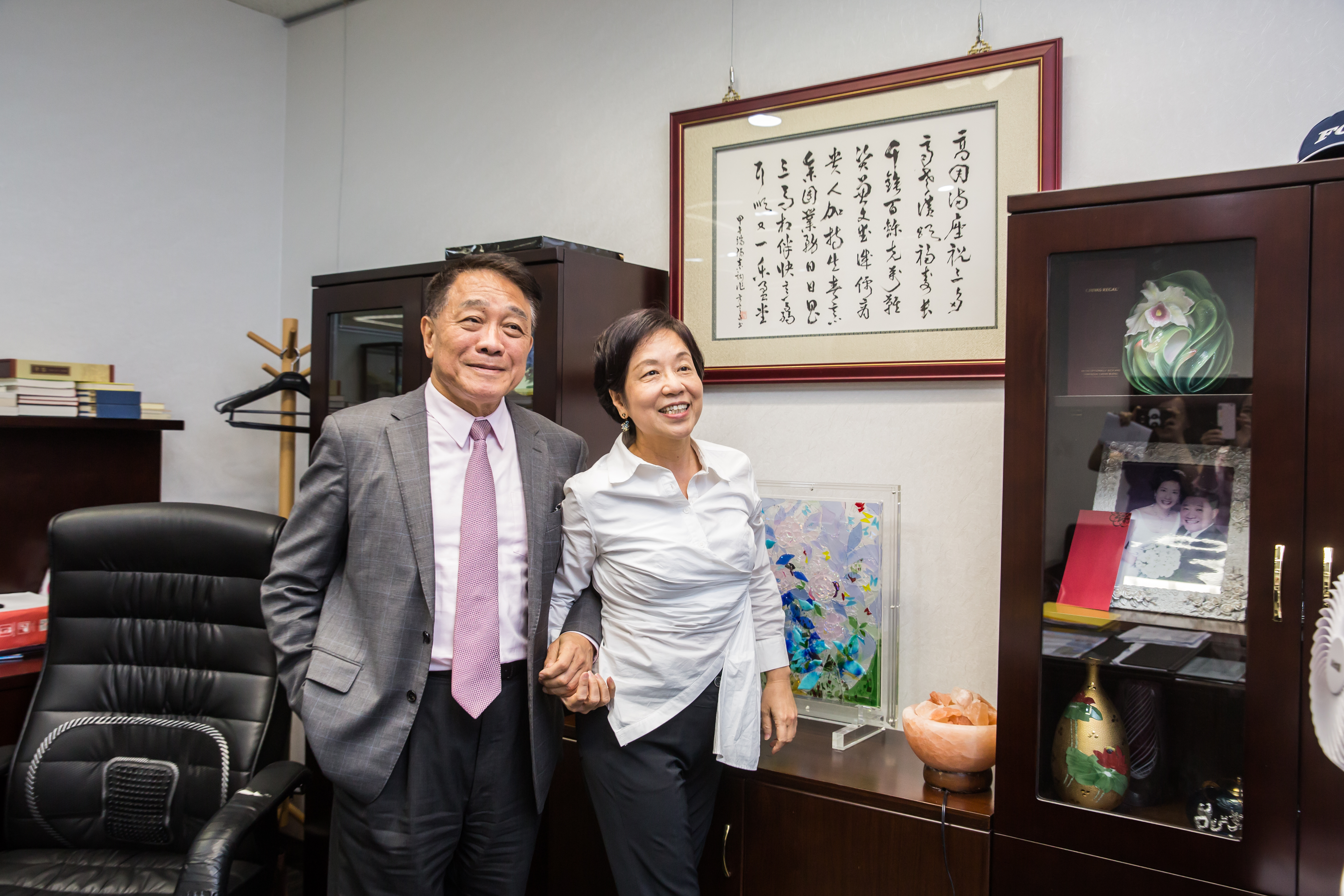 楊克誠(左)的辦公室裡,掛著一幅陳素甜(右)提詞的賀詩。