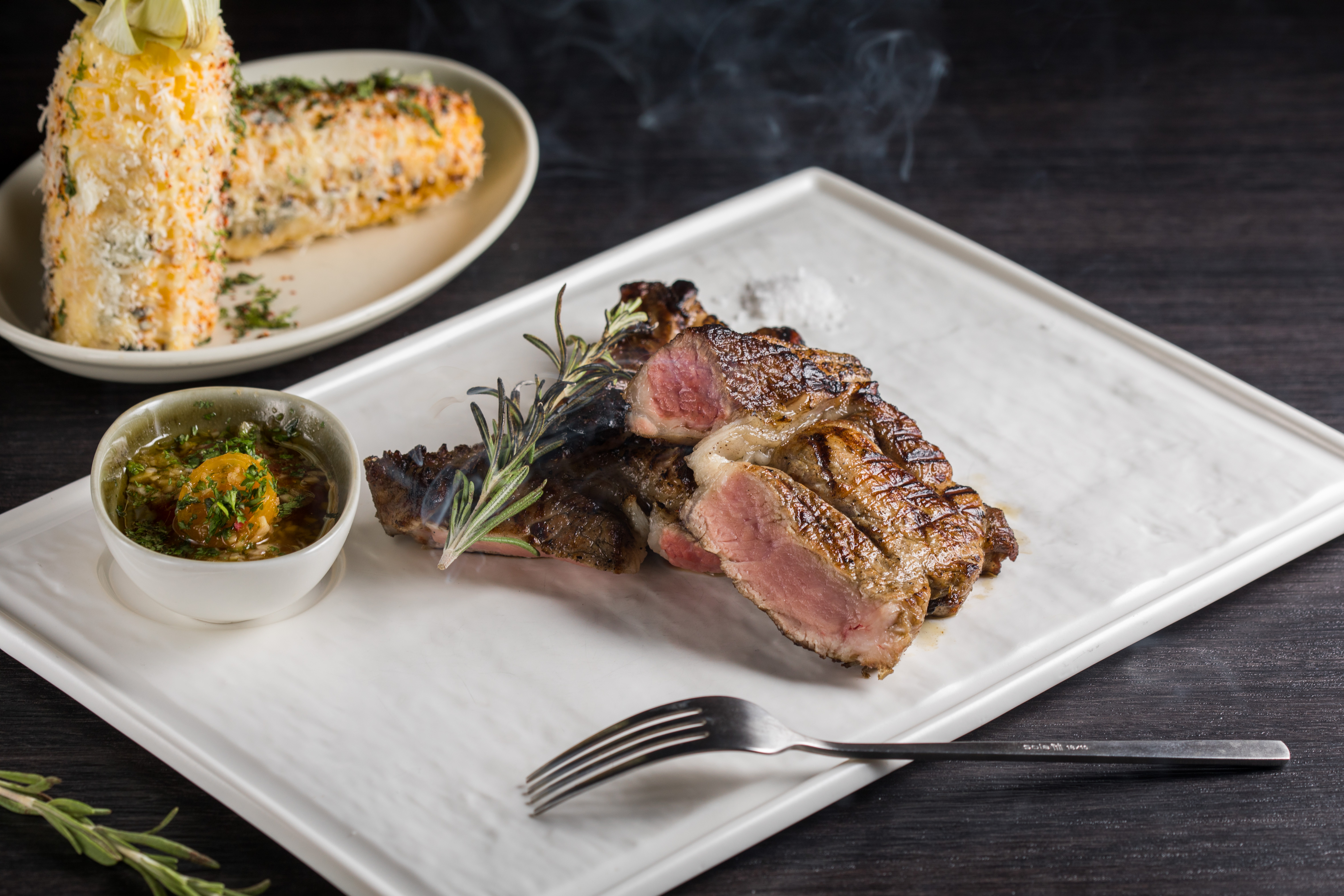 「本地黑豚帶骨肋眼」伴著煙燻香氣上桌，食欲也隨輕煙挑起。（1,080元／份）